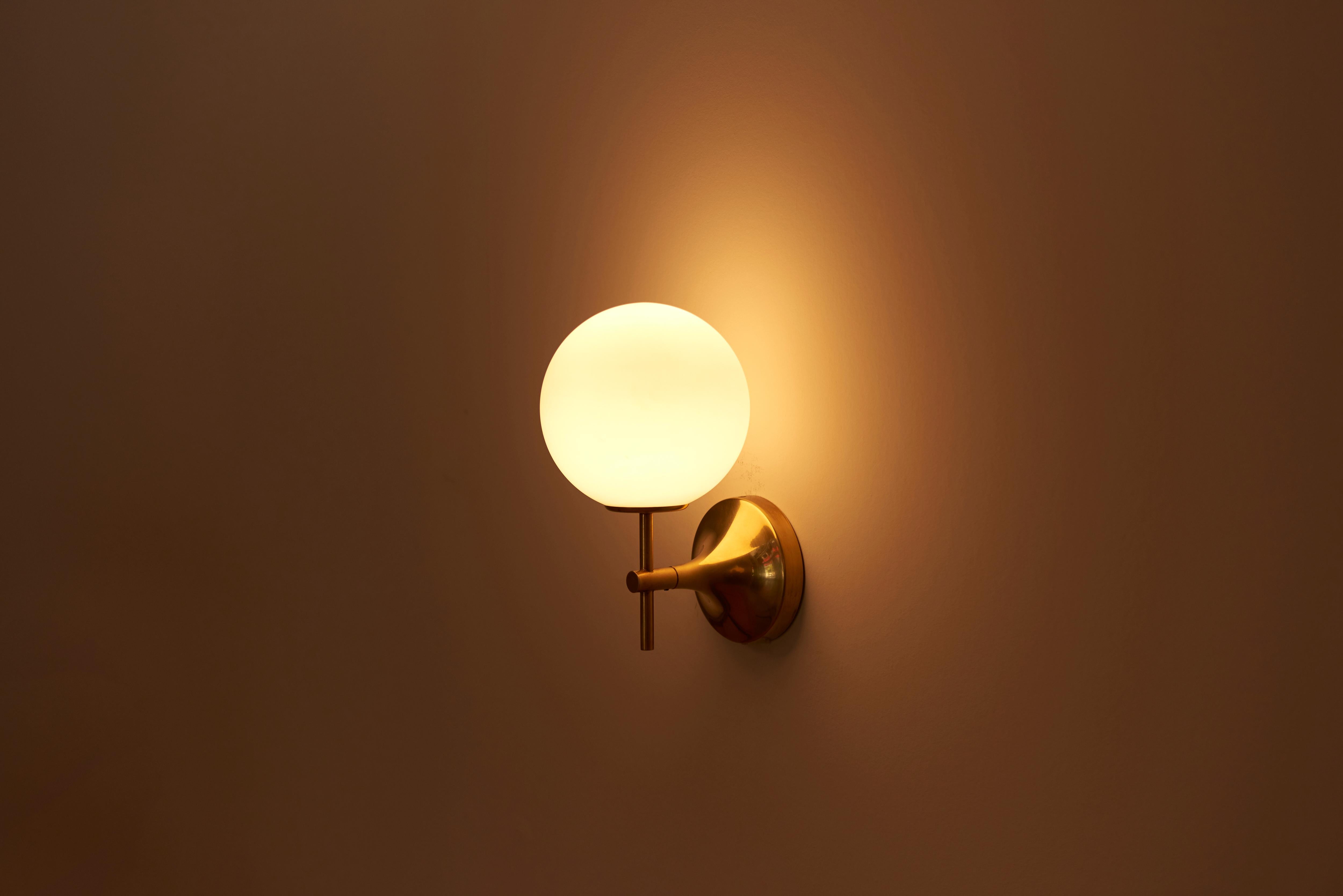 Pair of wall lights or sconces, composed of polished brass fixtures with white frosted glass globe shades.
Designed 1960s by Max Bill and manufactured by Temde Leuchten in Switzerland.

1 x E14 socket / each.

Please note: Lamp should be fitted