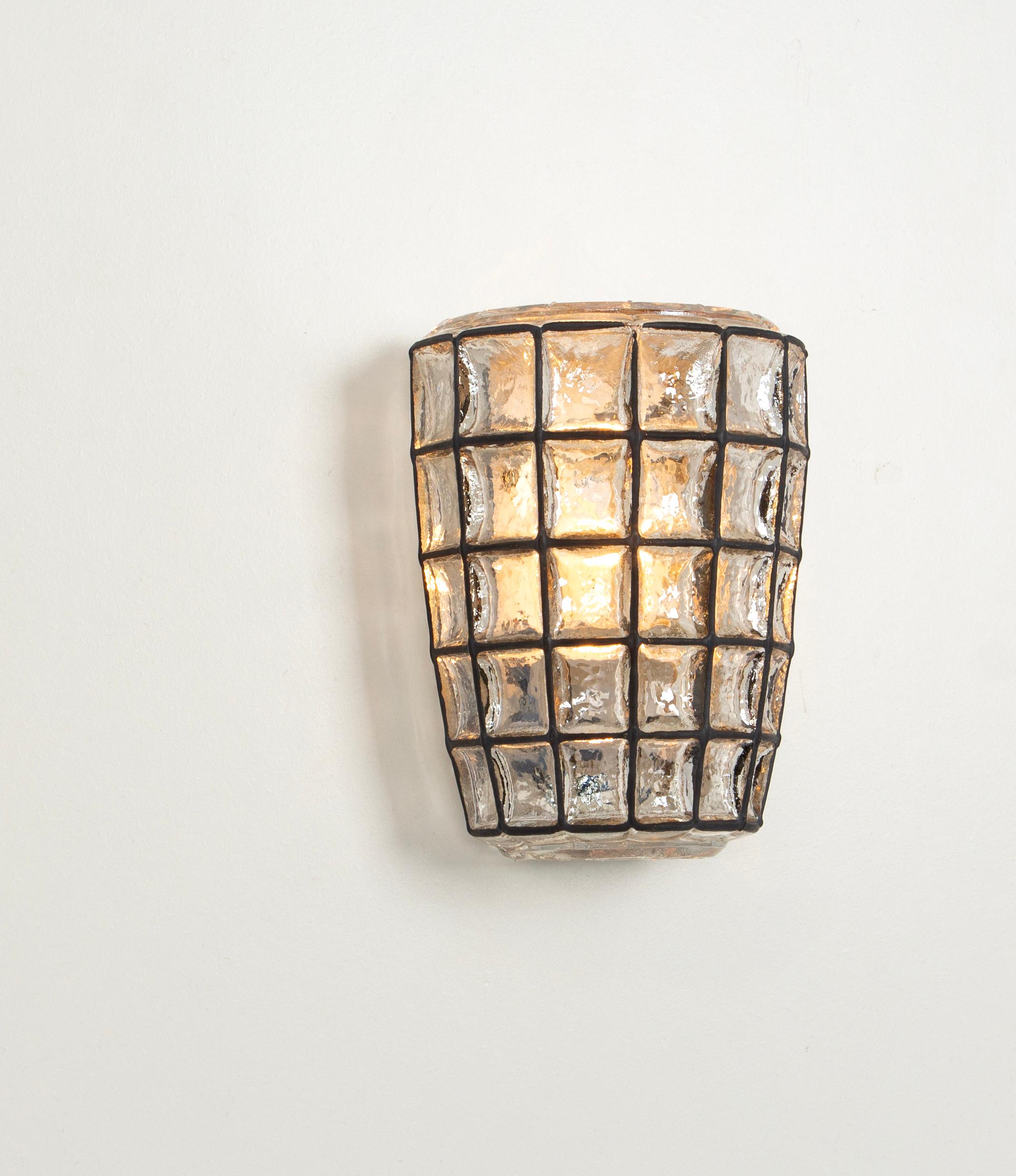 Pair of  Beautiful wall lights with a unique 'iron' design by Glashütte Limburg, Germany. Manufactured in midcentury, circa 1960.
Black 'iron' squares inlaid in thick clear glass. 

High quality and in very good condition. Cleaned and