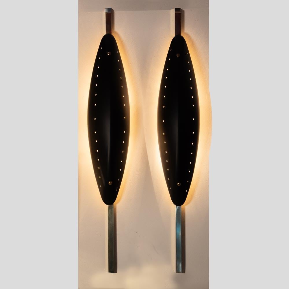 Pair of Vintage 1980’s Italian design wall lamps. Title “Parabola”
This pair of shield shaped sconcers have a sort of tribal / metropolitan feel and a very pleasant elegant and unusual look. 
They are extremely original, made of brass structure,