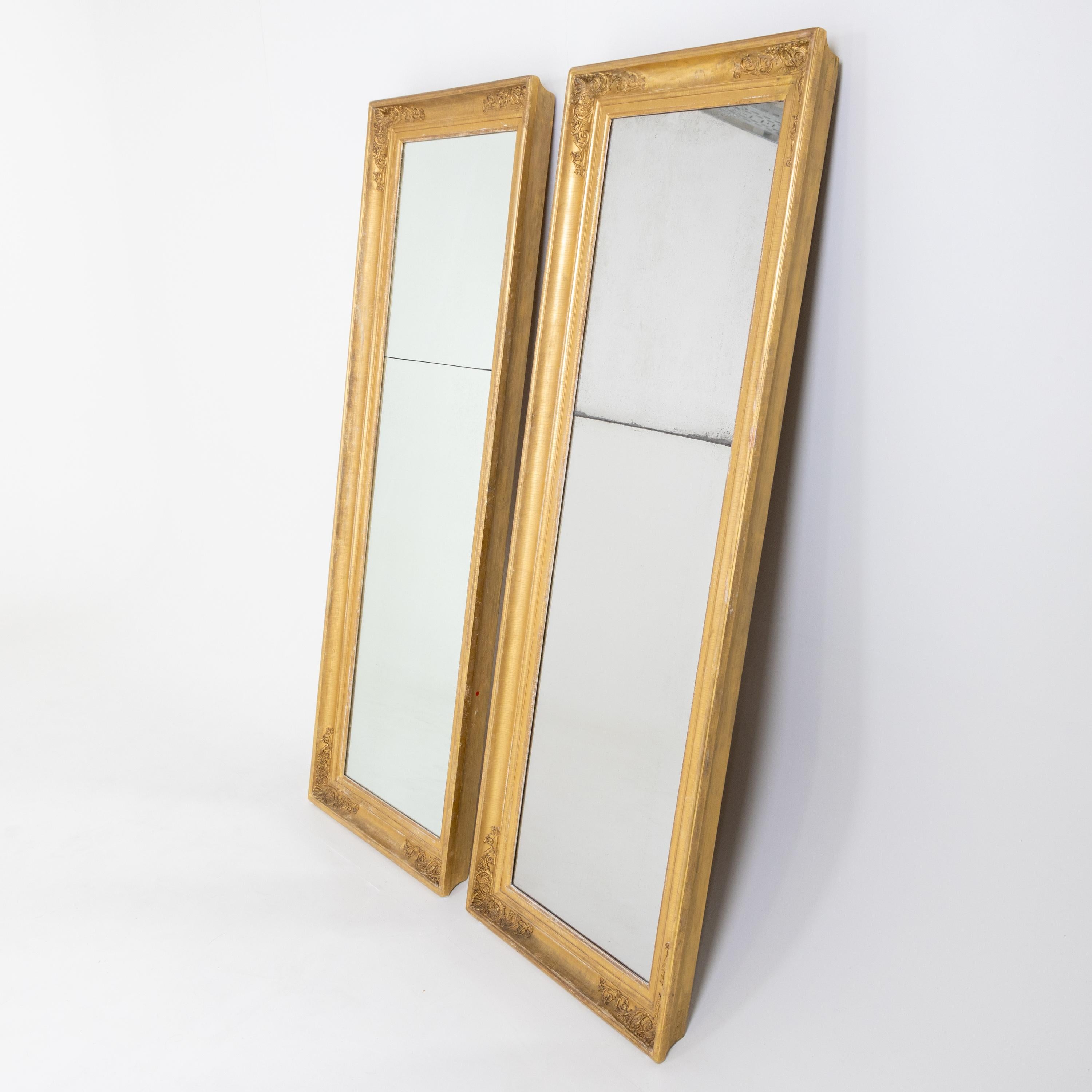 Pair of pillar mirrors in gold-patinated and stuccoed frame with profiled molding. The mirror panes are divided in the upper third. Patination is rubbed in places.

 