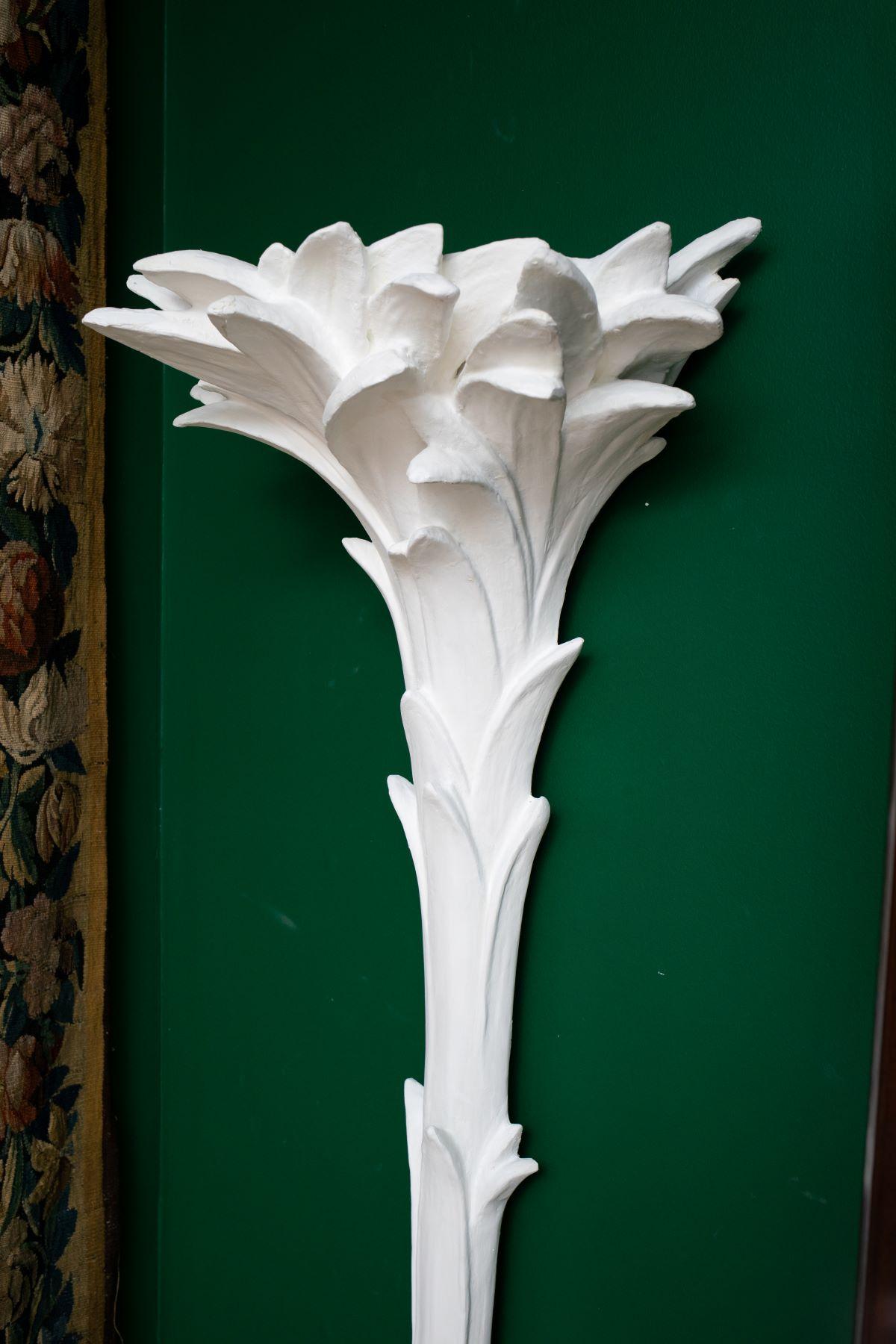 Pair of wall mount plaster floor lamps torchieres, by Syrie Maugham
 1940s plaster palm floor lamps each with a foliate top and a rockery base. Back is flat and mount flush to the wall. Very rare find.
Beautiful plaster texture with impeccable