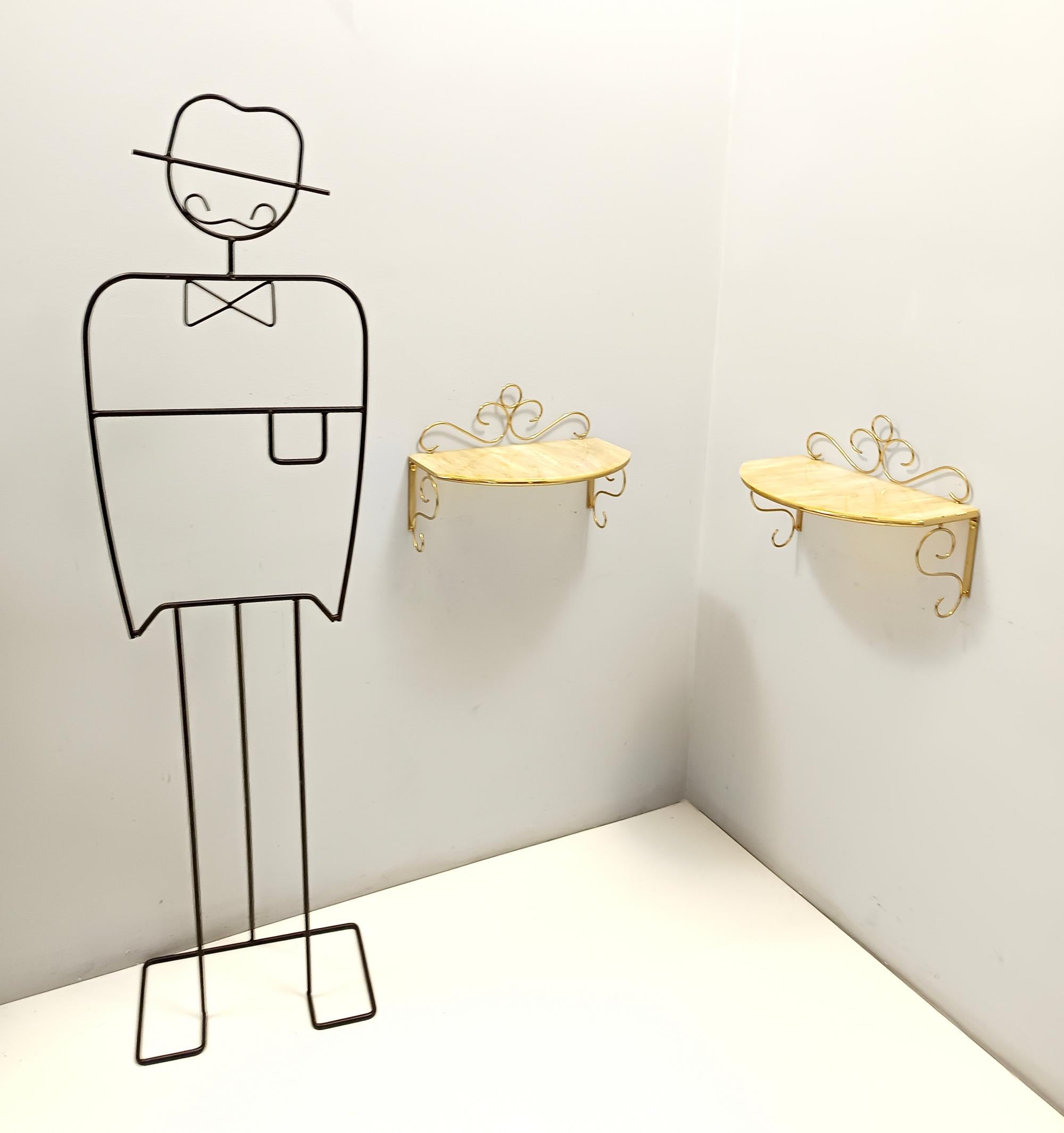 Fabricado en Italia, años 80.
Estas consolas / mesillas de noche murales tienen un marco de latón y una tapa de cristal de Murano policromado amarillo con efecto mármol.  
Pueden mostrar ligeras huellas de uso al ser vintage, pero se pueden