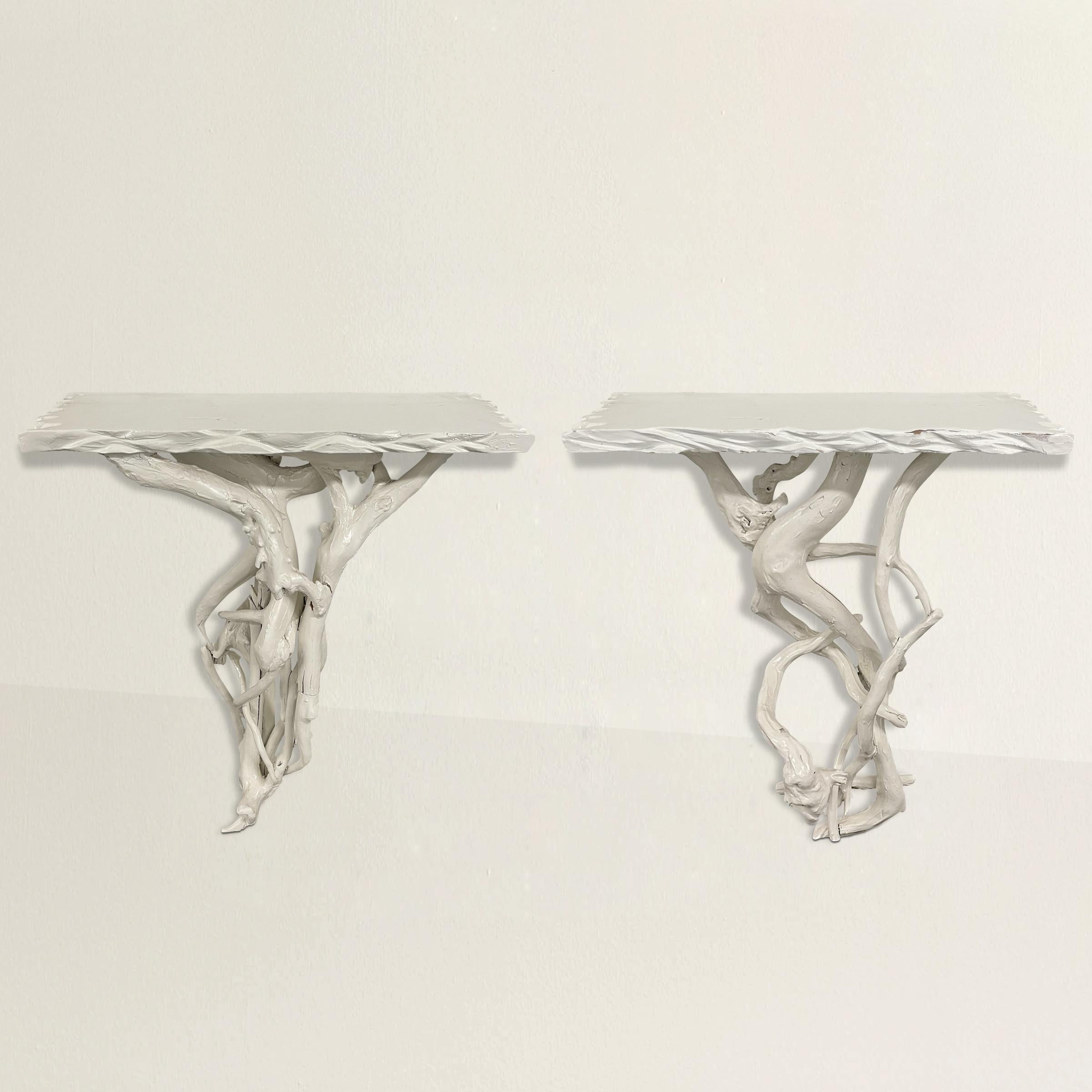 A chic pair of mid-20th century American wall-mounted lacquered console tables each designed with multiple twisted roots forming the bases and chip-carved wood tops, and both completely covered with a shiny white lacquer. Tables can be mounted so