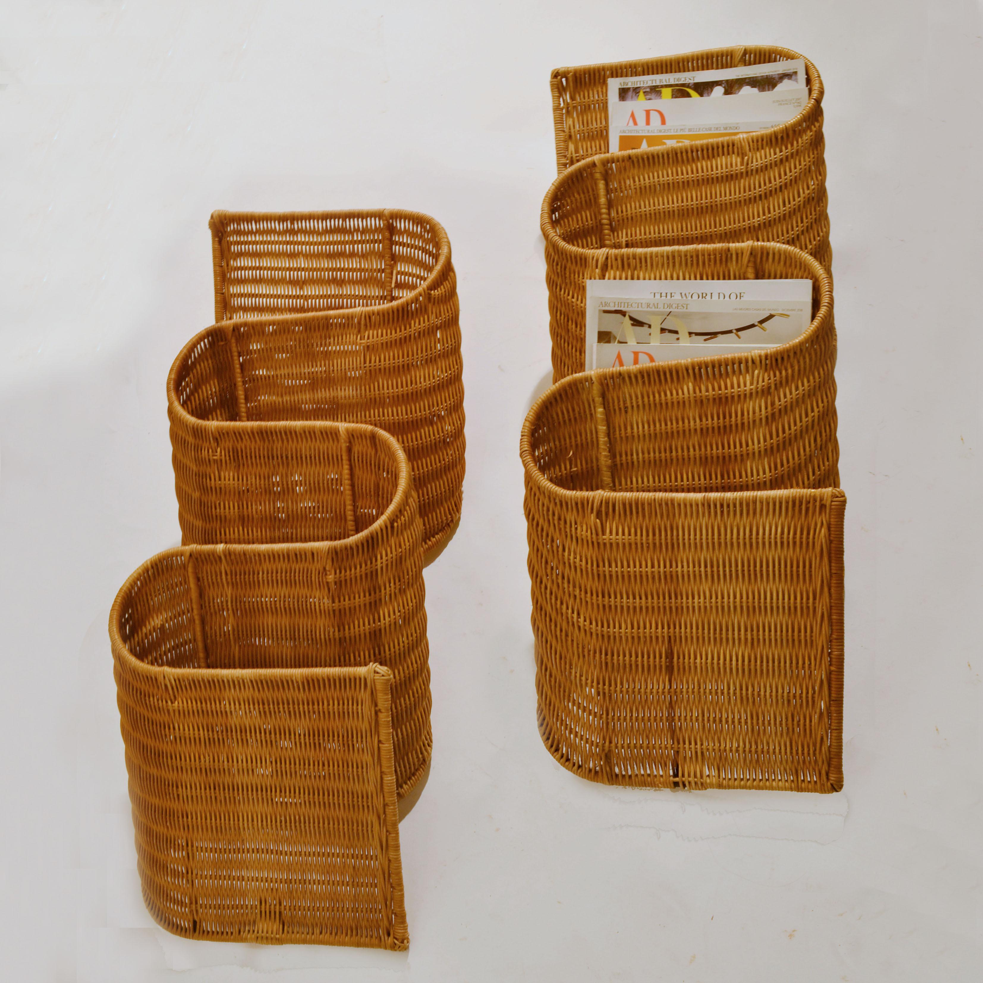 Wall mounted rattan magazine holders are very efficient and decorative, the way they snake along the wall. They each have 4 sections for magazines when hung vertically. The cane work is woven around a metal structure. They are made in Italy,