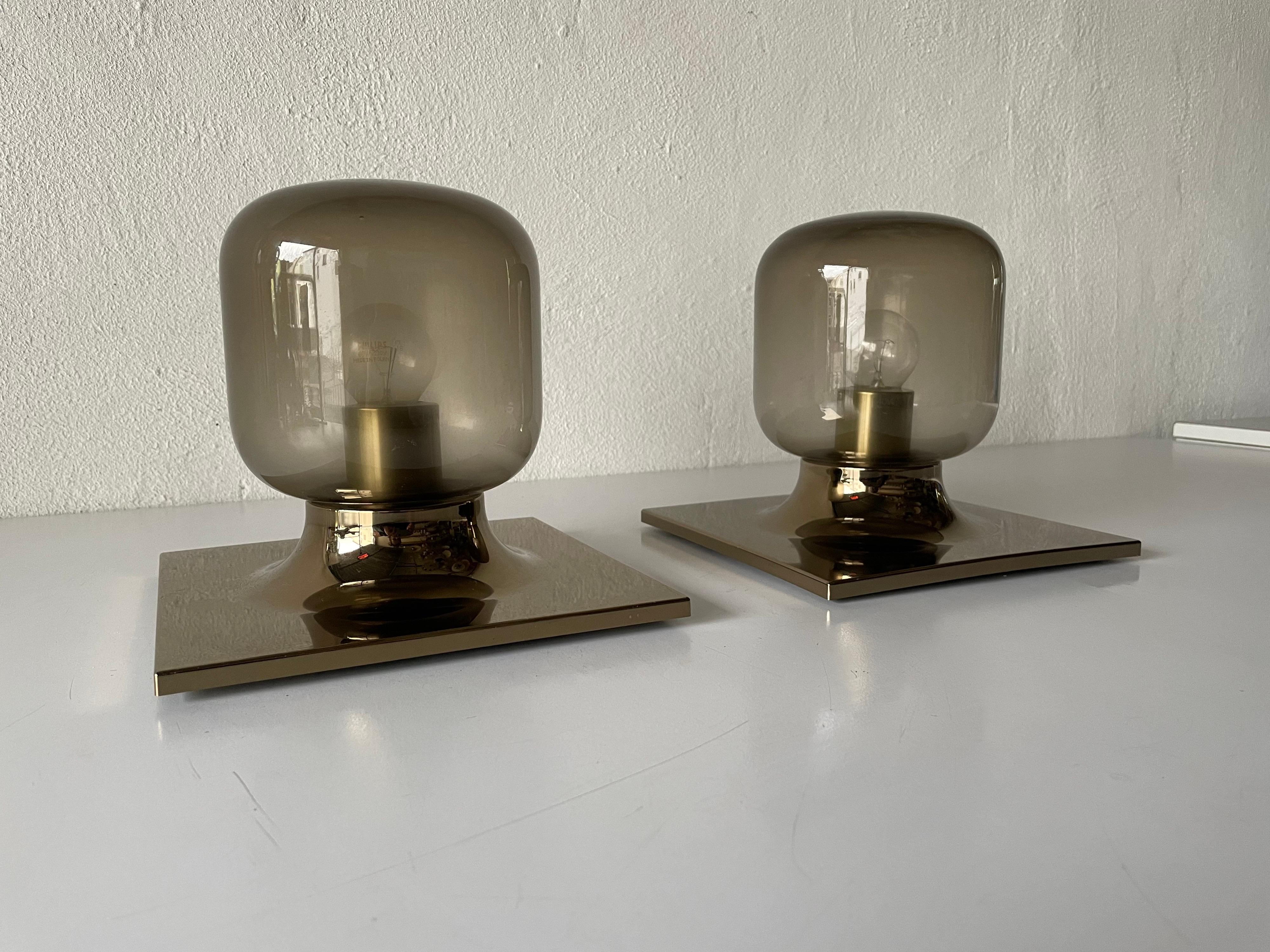 Smoked glass and gold metal pair of wall or ceiling lamps by Motoko Ishii for Staff, 1960s, Germany
Very elegant and Minimalist sconces

Lamps are in very good condition.

These lamps works with E14 standard light bulbs. 
Wired and suitable to