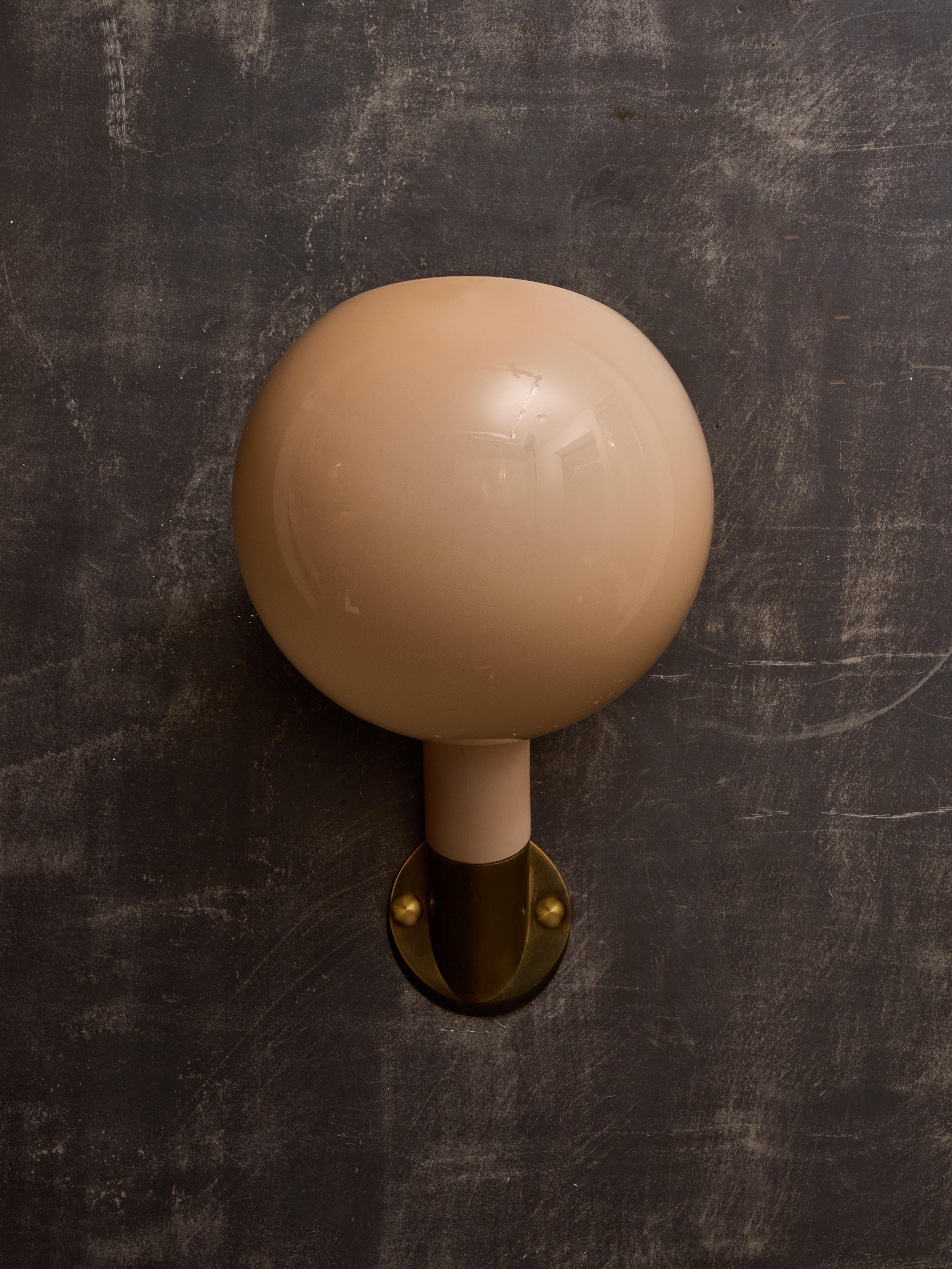 Pair of brass and glass wall sconces, model 2689, made by Fontana Arte and designed by Piero Castiglioni and Gae Aulenti. These sconces feature a brass backplate with an angled arm of light, that supports a light pink glass pivoting sconce.

GAE