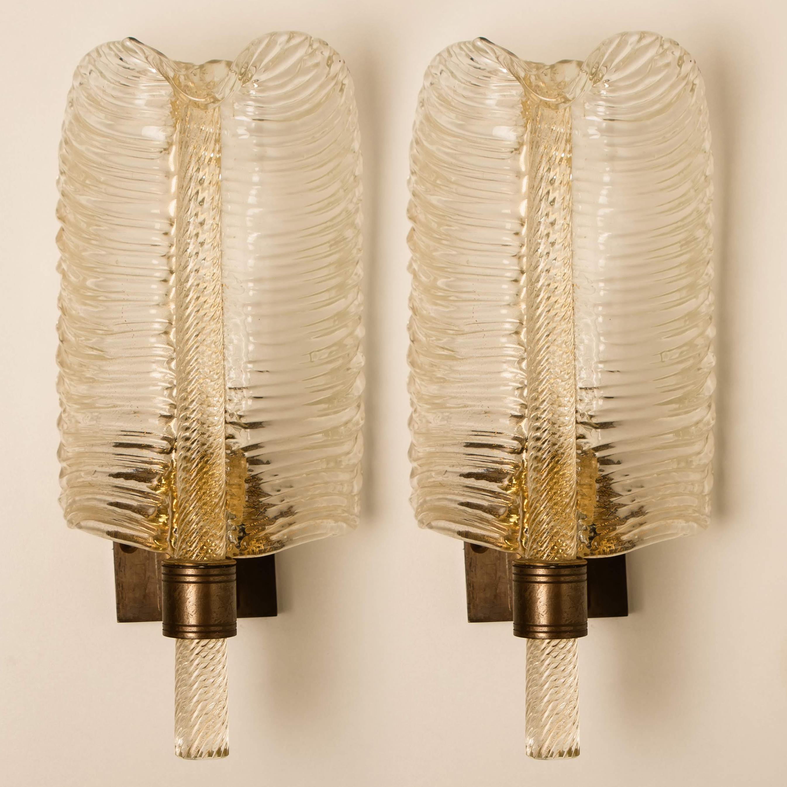 A pair of elegant and exquisite hand blown Murano glass Barovier & Toso wall sconces. Each light fixture consists one blown Murano glass leave. Mounted on an old brass frame. The leaves refract light beautifully. 
 
Cleaned and well-wired, in full