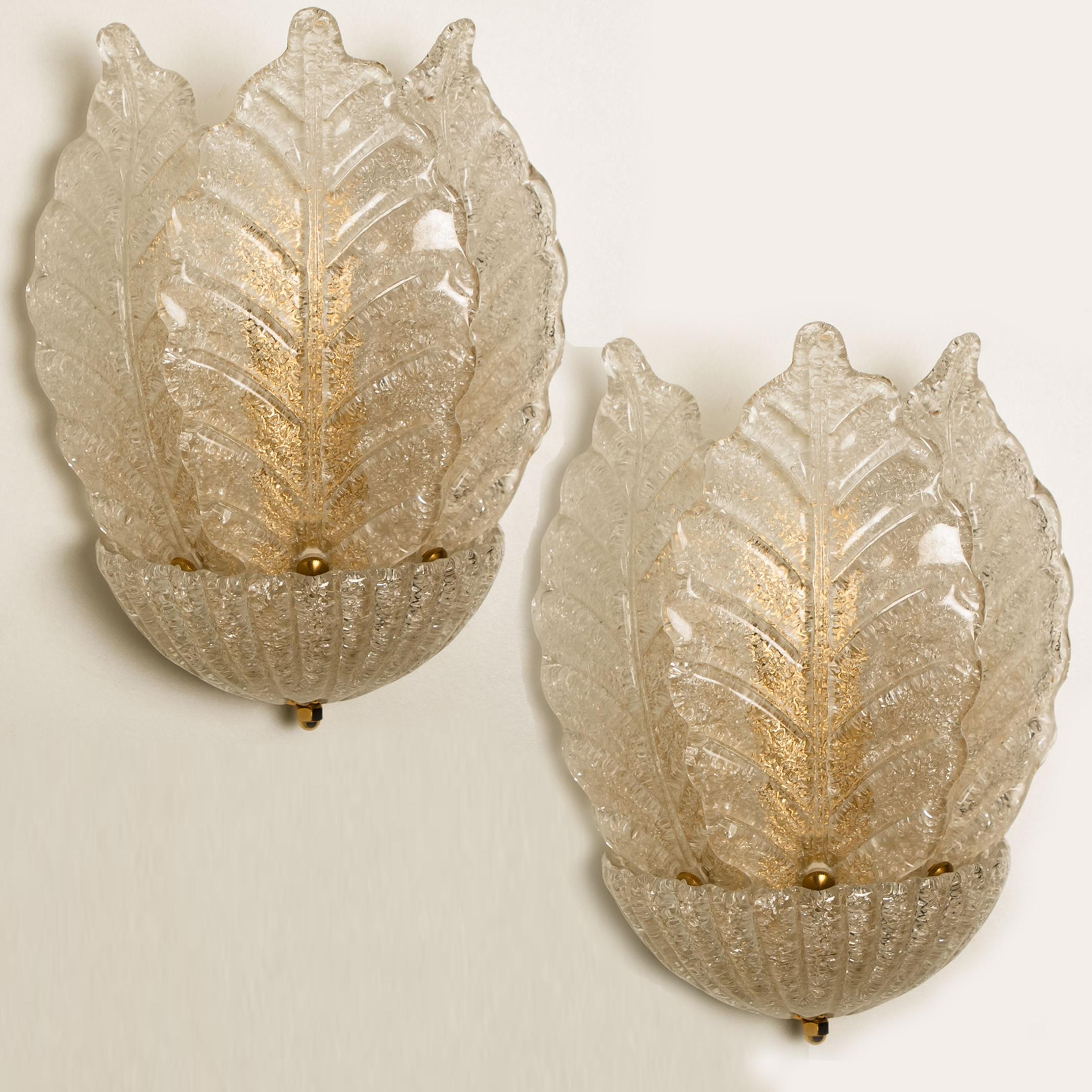 A pair of elegant and exquisite hand blown Murano glass Barovier & Toso wall sconces. Each light fixture consists three blown Murano glass leaves surrounded by a blown cup. Mounted on a gold-plated brass frame. The leaves refract light