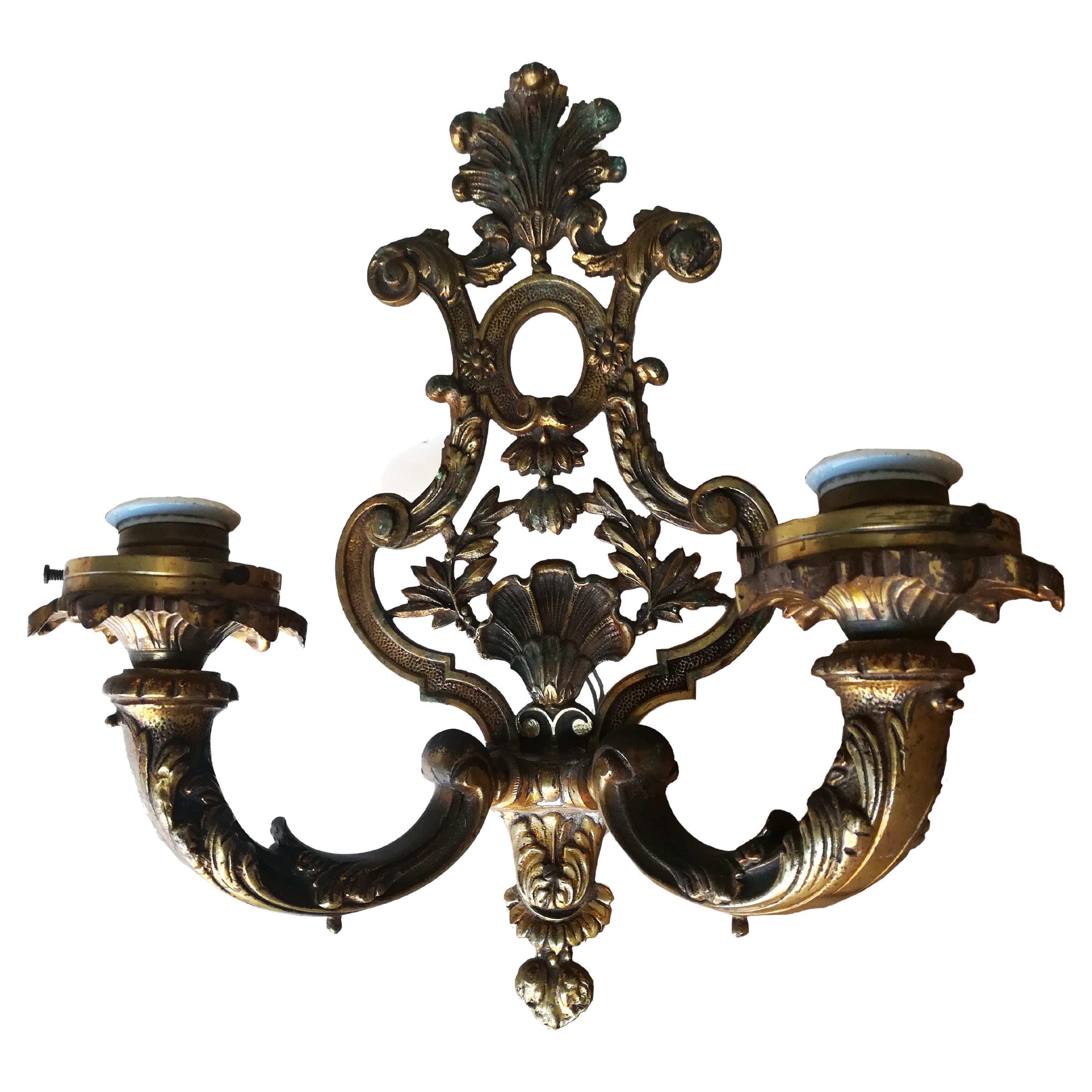 Lampada da parete in ottone massiccio o in ottone stile Impero con due bracci.

Questa applique da parete in stile Impero ha un aspetto rigido, solido e forme geometriche di base. Decorato con foglie d'acanto e conchiglie.

Sono allo stato