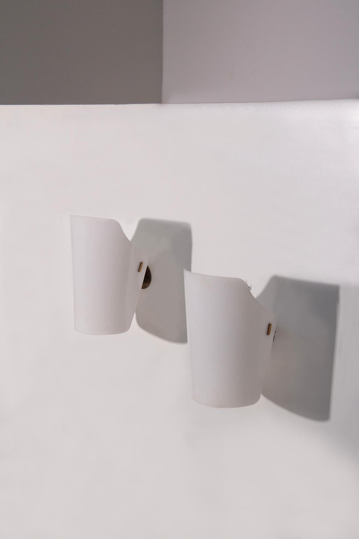 Paire de lampes murales par Gino Sarfatti pour Arteluce, années 1950 - Laiton et plexiglas blanc, Design publié
Rare et raffinée, cette paire d'appliques murales du milieu du siècle par Gino Sarfatti pour Arteluce incarne l'élégance et l'ingéniosité