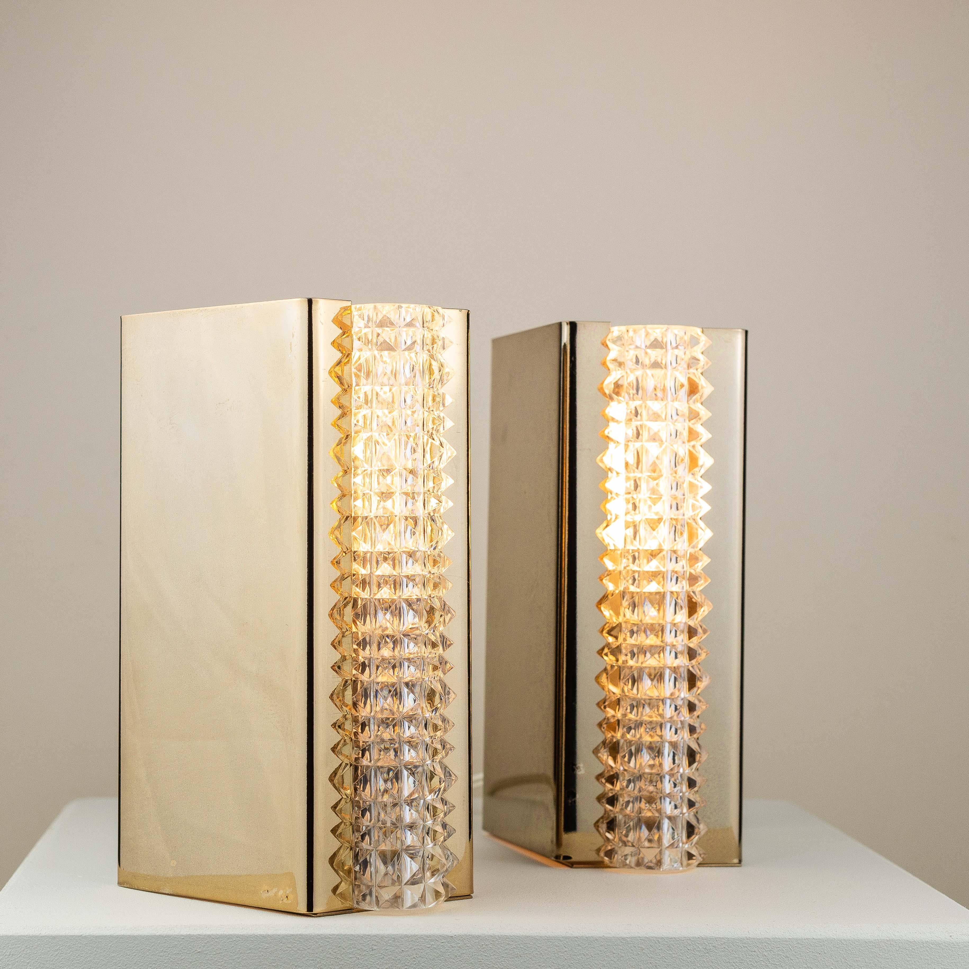 Pair of Wall Sconces in Brass and Glass, France 1960s.

Wall sconces featuring very graphic and contemporary lines. 

The brass parts are polished and shiny, which gives the sconces a high reflecting mirror effect. Glass tubes are in perfect