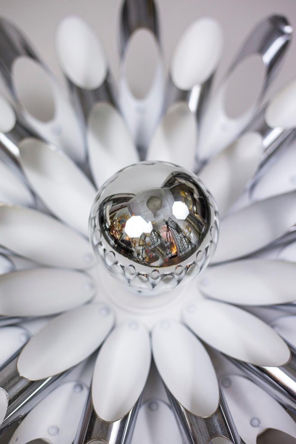 Pair of wall sconces in chromed and white lacquered metal figuring flowers with concentric petals, in a slanting cut tubular shape.

Italian work realized in the 1970s.

Functional electrical system.