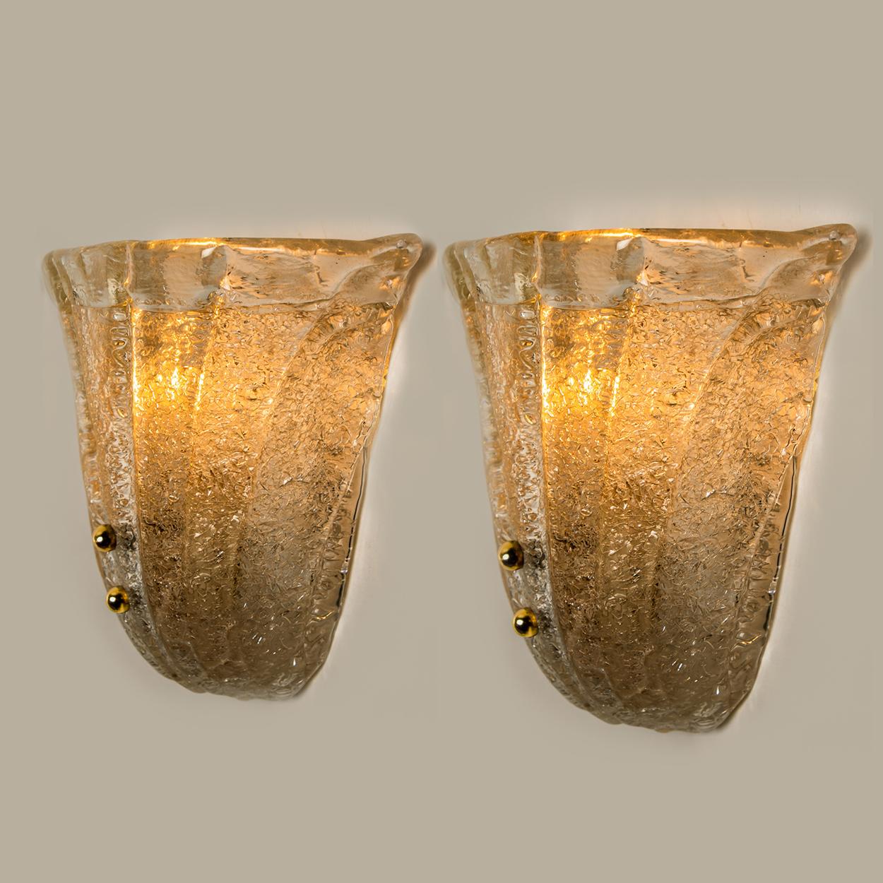A pair of elegant and exquisite hand blown Hildebrand wall sconces. Each light fixture consists a tulip shaped glass leave surrounded by a blown cup. Mounted on a chrome frame with brass round crews. The leaves refract light beautifully.

Cleaned