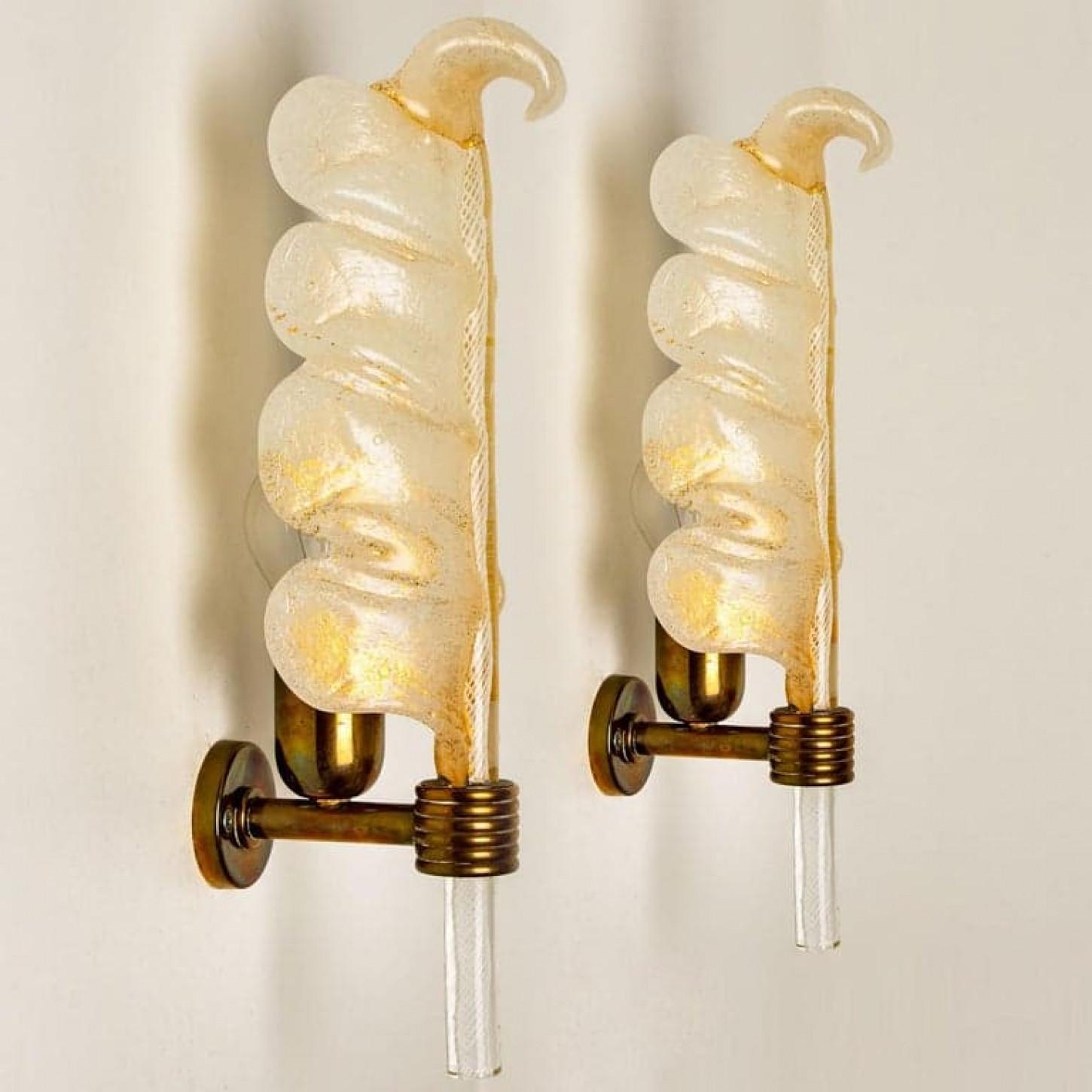 Pairs of gorgeous hand blown Murano glass Barovier & Toso wall scones with special gold inclusions. Each light fixture consists of one blown Murano glass leaf. Mounted on a brass frame. The glass leaf reflects the light beautifully. It fills the