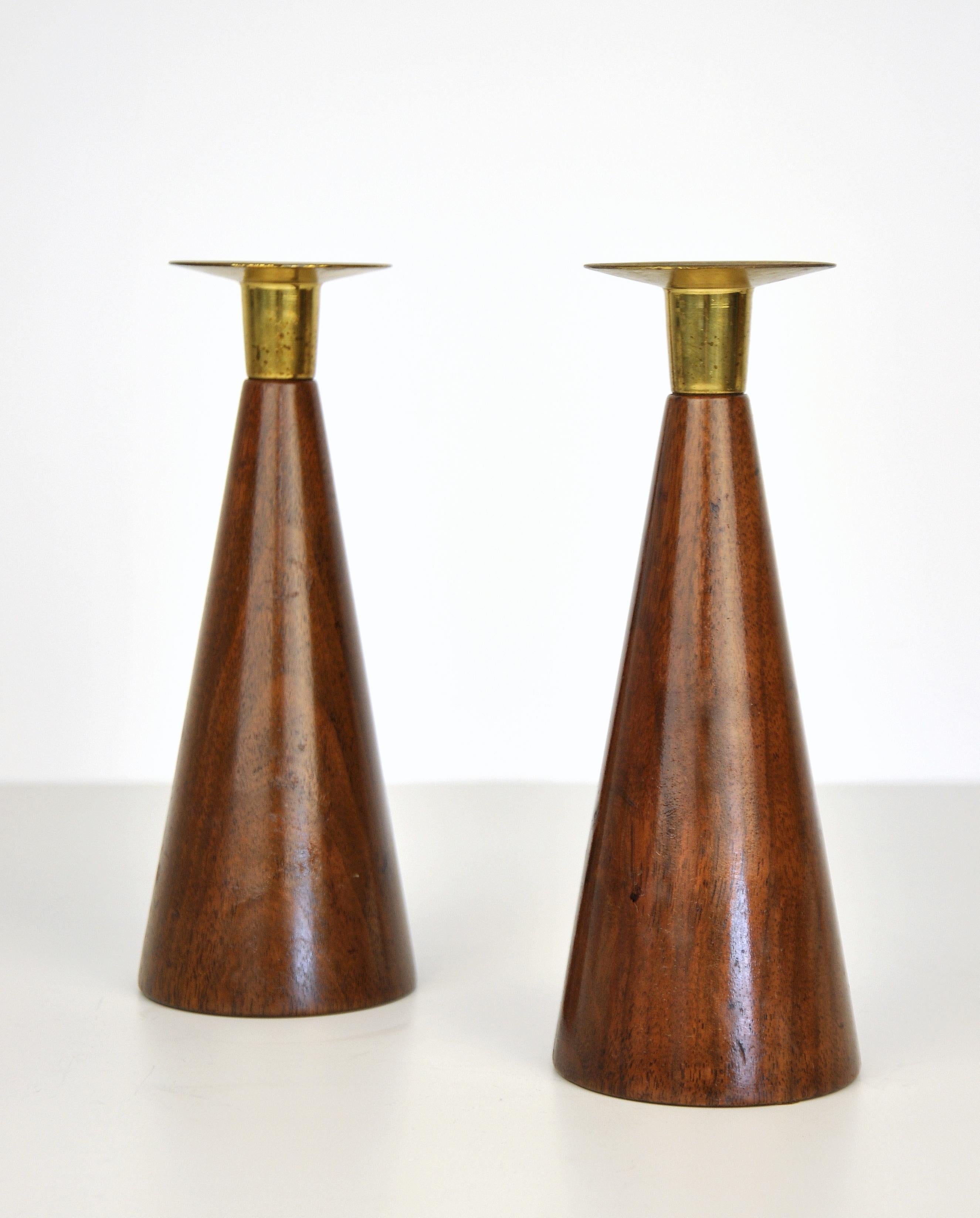 Pair of midcentury modern Tony Paul style cone shaped walnut and brass candleholders. The tapered conical / funnel shaped / pyramid walnut body of the candlestick is topped by a brass bobeche. Work well with midcentury, Scandinavian and organic