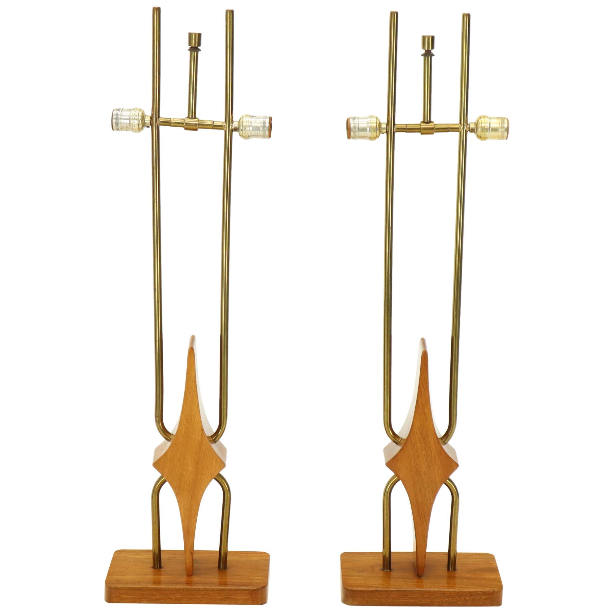 Pair of mid-century modern walnut and brass table lamps. Weaved rounded rectangular shade. Shades measure: 20 x 11 x 9