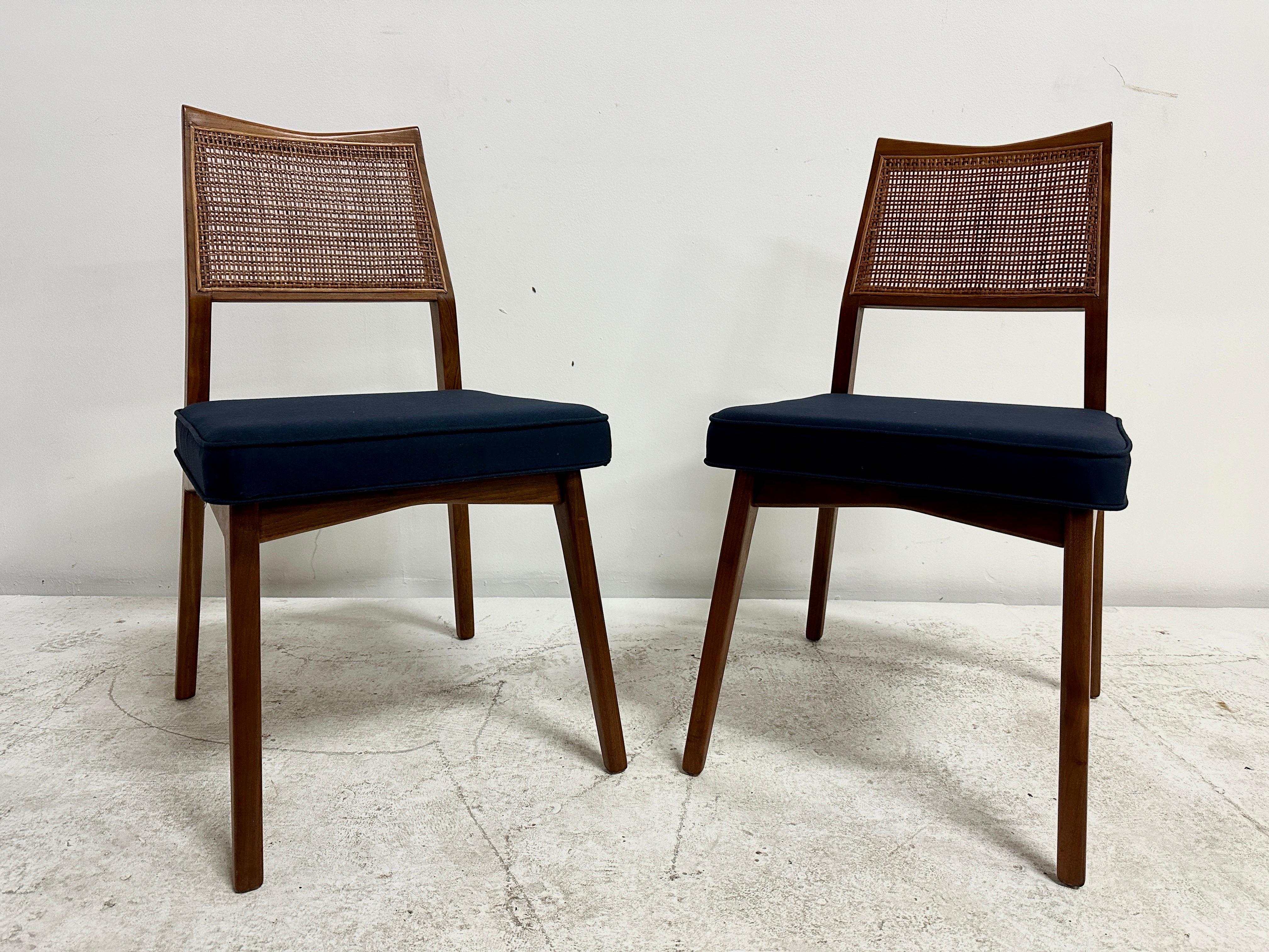 This wonderfully perfect mid-century modern pair of side chairs in the style of Paul McCobb, boast an intact woven cane backrest, walnut kick-back chair frame and relatively unused deep blue fabric seats.  Great for extra seating, host/hostess