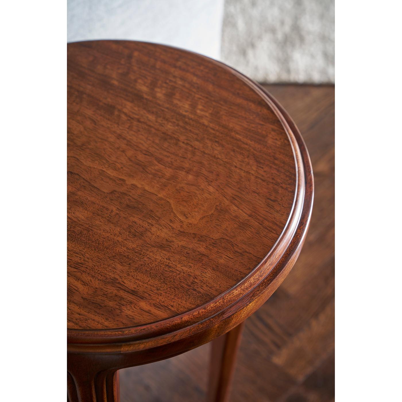 Cette table à la silhouette raffinée, aux pieds fuselés et aux détails subtilement incrustés, respire l'élégance du début du XXe siècle. Le grain chaud du bois rehausse son attrait luxueux, tandis que les pieds coiffés de nickel ajoutent une touche