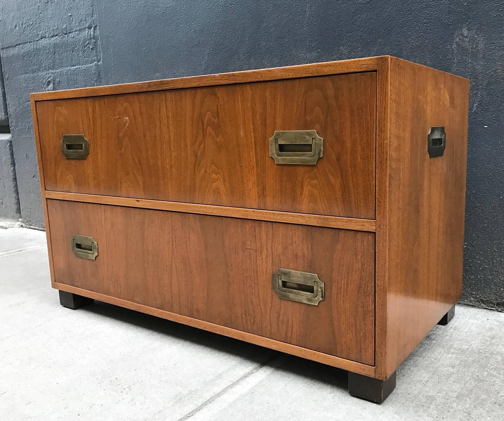 Pair of walnut baker Campaign chests. Has original brass hardware, black lacquered feet with two pull-out drawers.