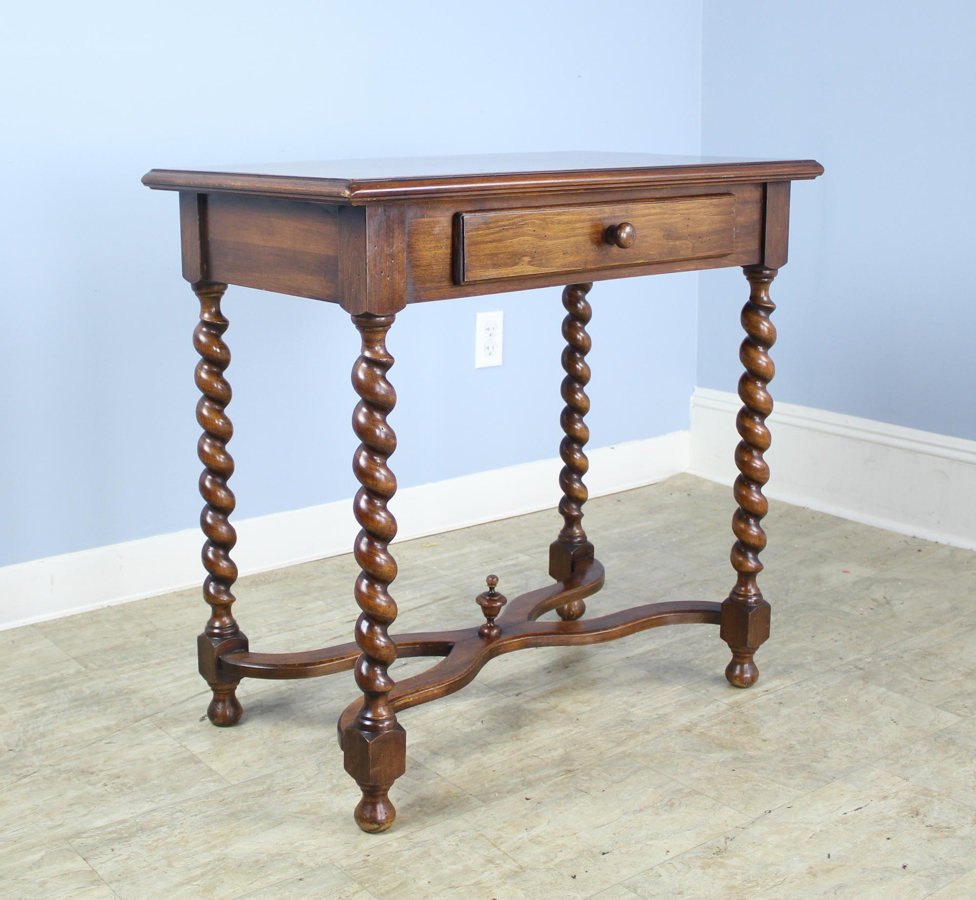 A pair of walnut side tables or nightstands with eye-catching barley twist legs and shaped stretches. Sweet final at the center of the stretchers. The tops are in good condition with lovely color and grain. Would be right on either side of a sofa or