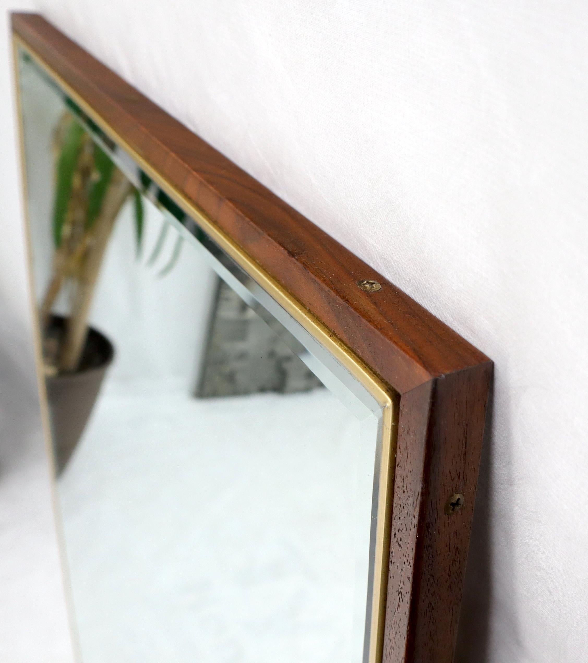 Pair of outstanding quality Mid-Century Modern neat beveled edge brass and walnut frame boat shape mirrors atr. to Paul McCobb.