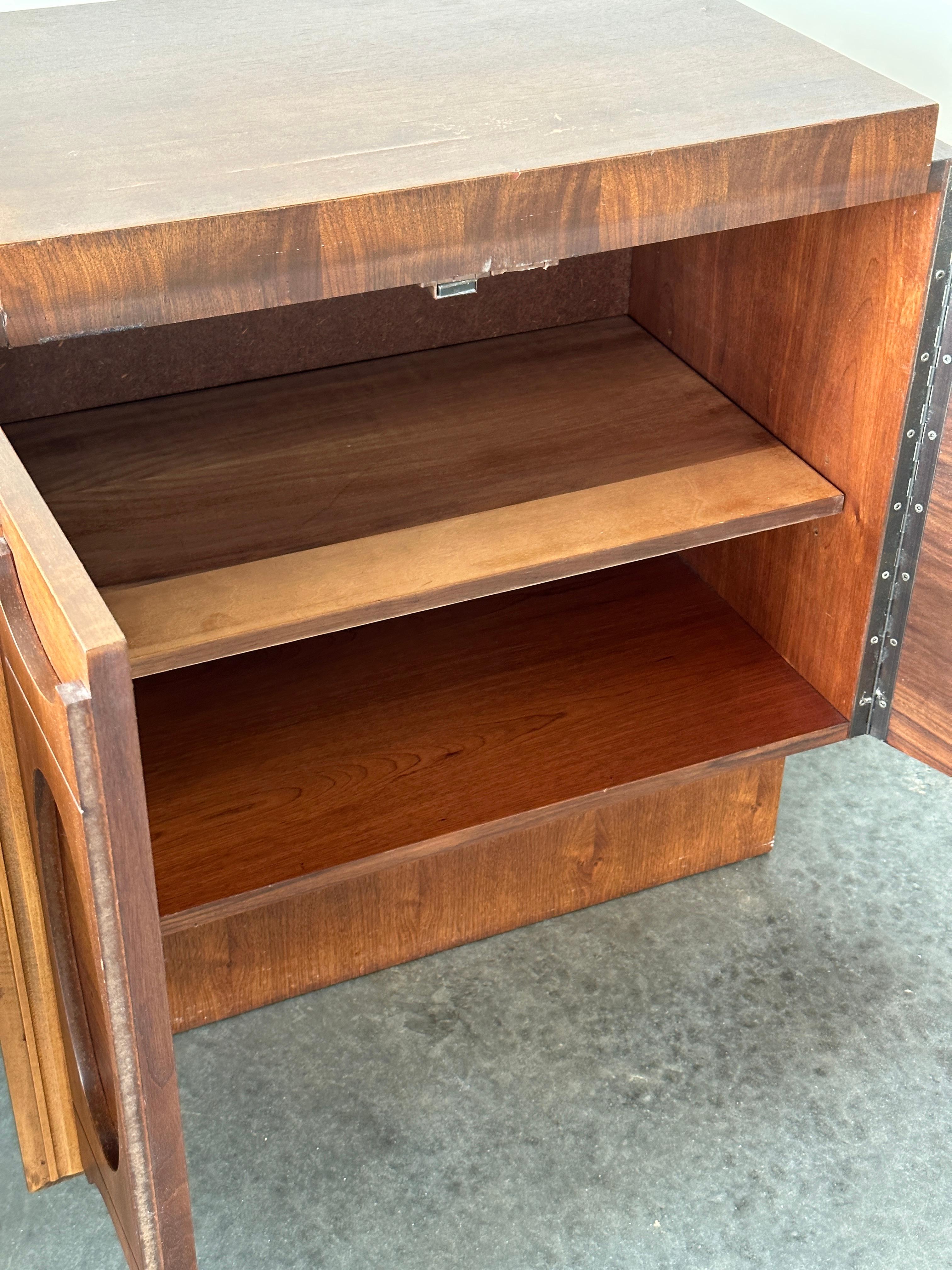 This pair of oiled walnut nightstands is a fine example of Canadian furniture design from the 1970s by Tabago Furniture. Inspired by the brutalist style of American designers like Paul Evans, the front of these nightstands feature doors with a