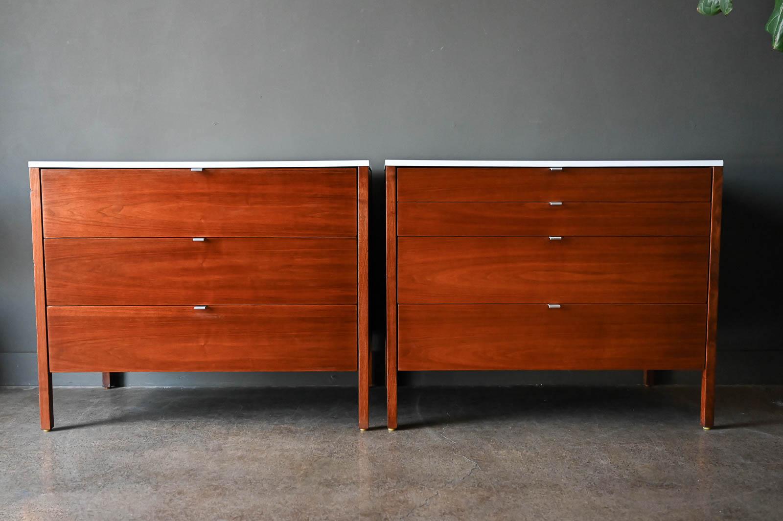 Pair of walnut cabinets by Florence Knoll, ca. 1960. Beautiful matched pair of walnut cabinets or chests by Florence Knoll for Knoll, inc. These pieces have wonderful book matched walnut grain with white laminate tops. The backs are also done in