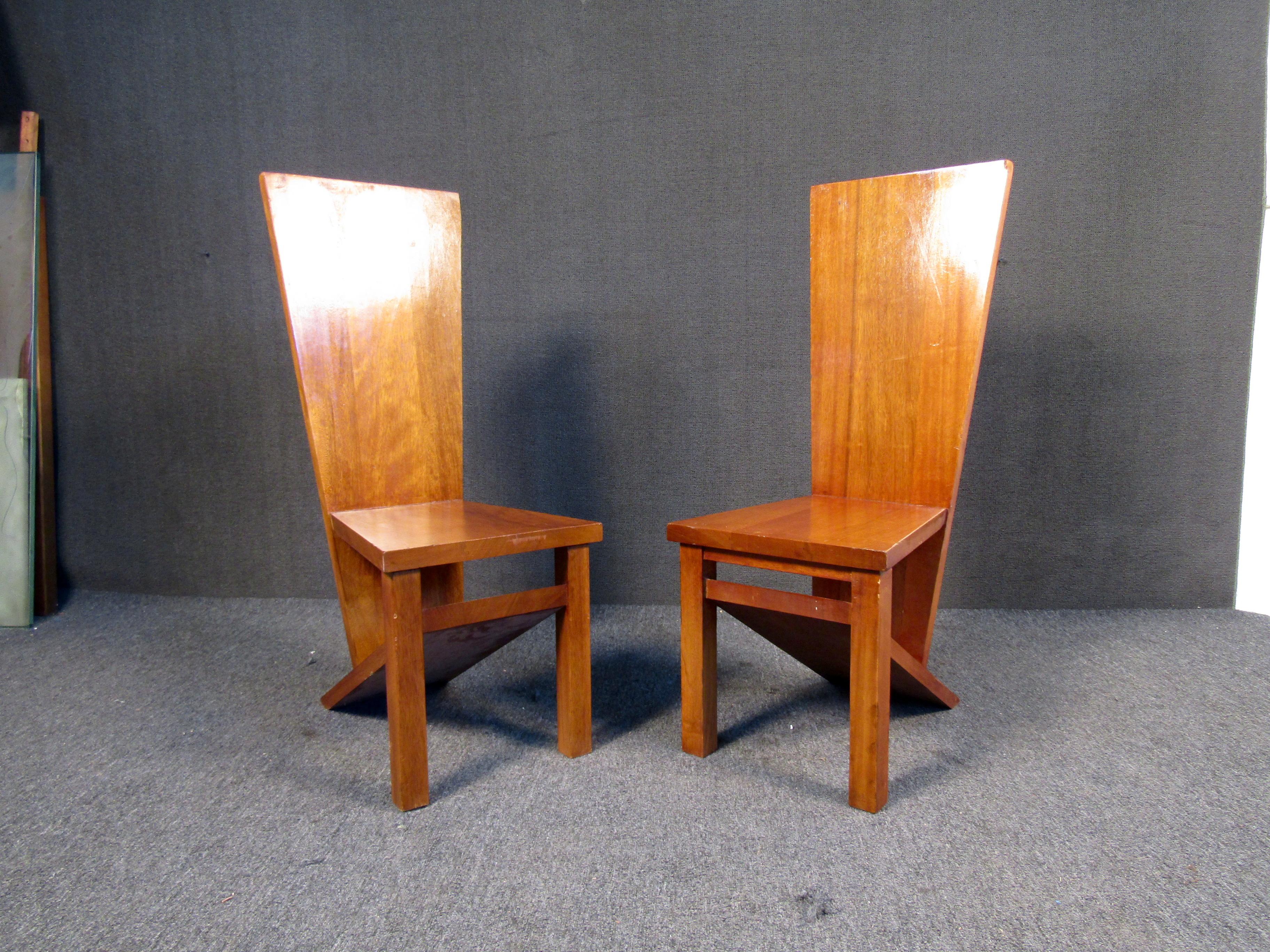 Pair of walnut finish wooden slab chairs sold as a set. Their monolithic form are sure to stand up to heavy daily use. A rustic, minimalist design borrows readily from the chairs of Gerrit Thomas Rietveld and Frank Lloyd Wright. A fine example of