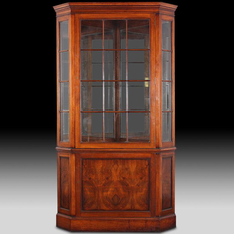 Unusual pair of walnut Georgian revival corner cabinets, the upper sections with three glass shelves behind glass paned doors over lower enclosed storage behind figured figured walnut veneered doors. Lovely quality cabinets with extra details such