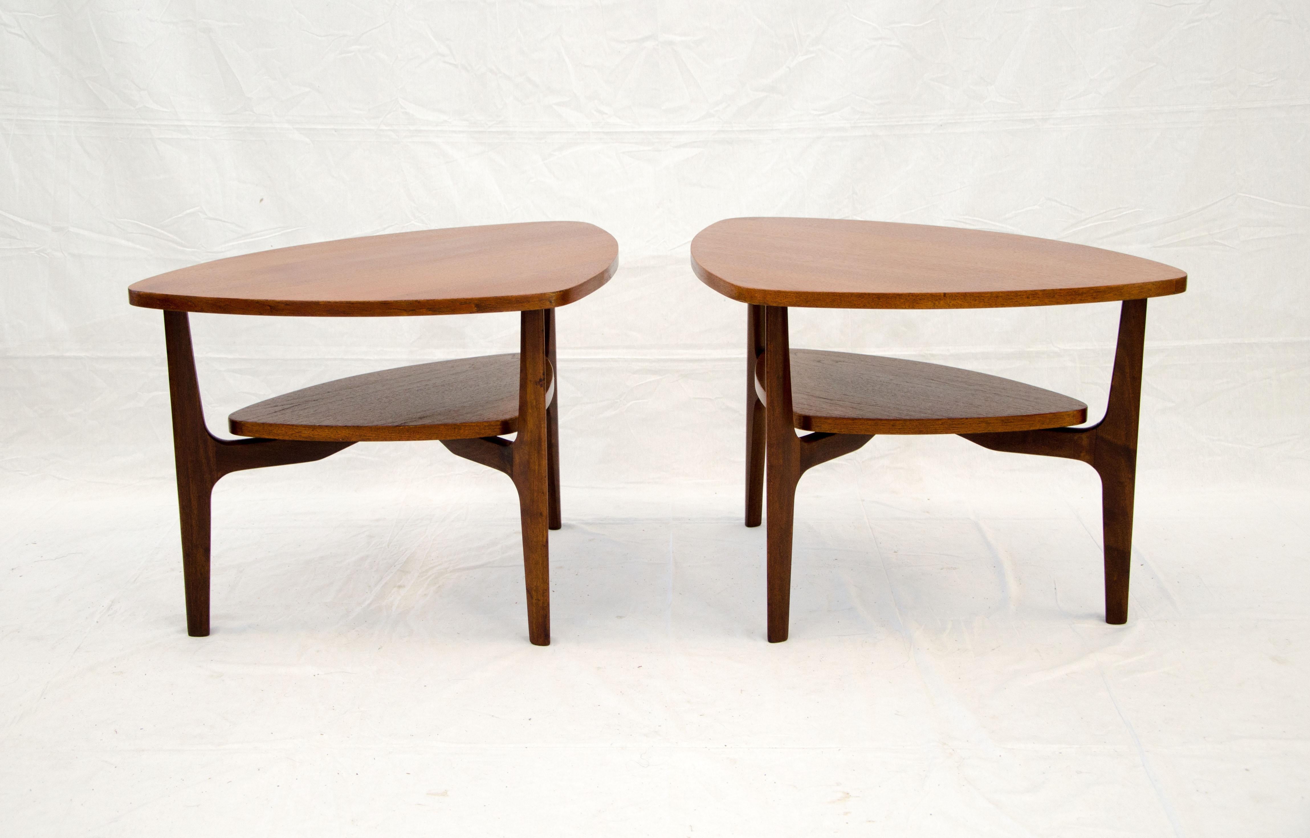 Pair of organic shaped walnut end tables that can be positioned in several different ways. The shelf and top are supported by a three-legged base. There is 7