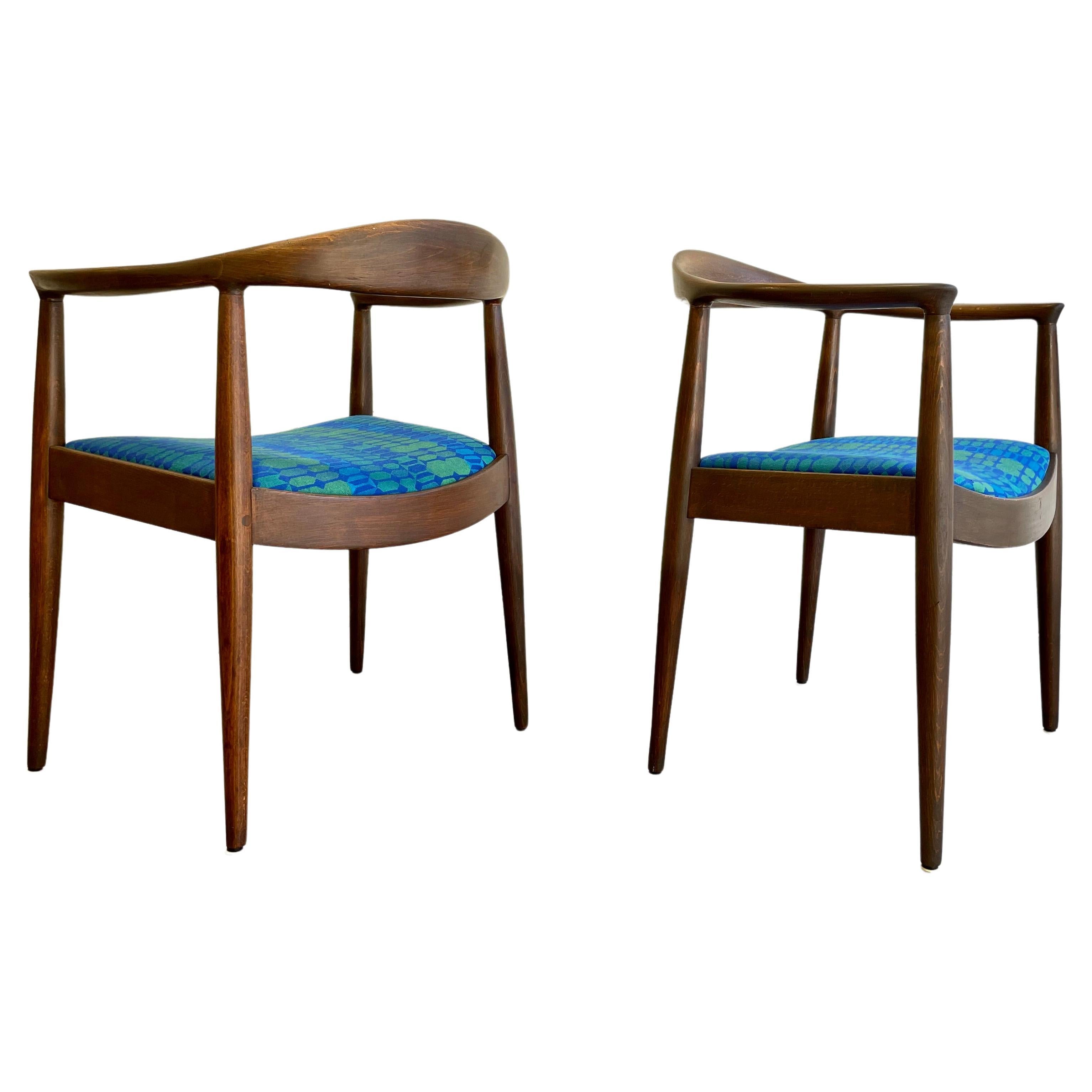 Vintage Mid-Century Modern Lounge Chairs in the style of Hans Wegner. Elegant curvilinear walnut frame is beautifully constructed and the chairs are newly refinished showcasing the gorgeous wood grains. The chairs have been newly reupholstered in an