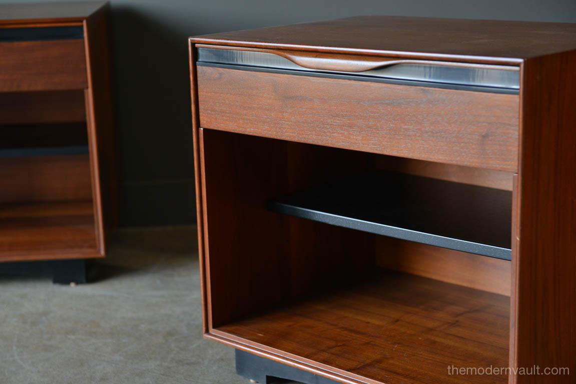 Pair of walnut nightstands or end tables by John Kapel for Glenn of California, circa 1968. Beautiful walnut with black laminate trim and ebonized adjustable shelves. Sculpted walnut drawer pull. Professionally restored in showroom condition. Sold