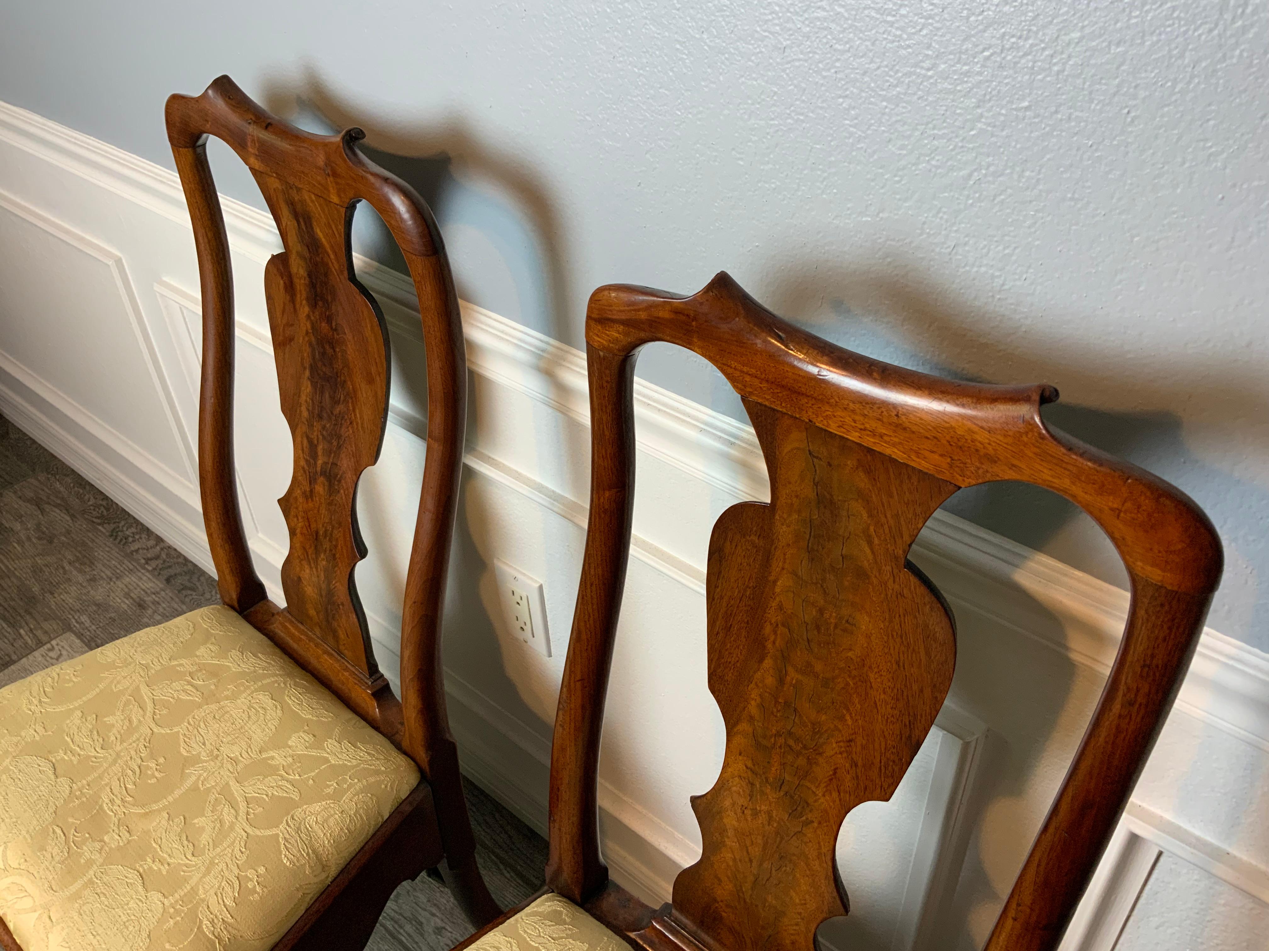 A very nice pair of Queen Anne walnut side chairs with shaped back splat above a drop in seat supported on cabriole leg and pad foot. Very good original condition with the original seat frames. Very nice carvings on the top crest and legs. Excellent