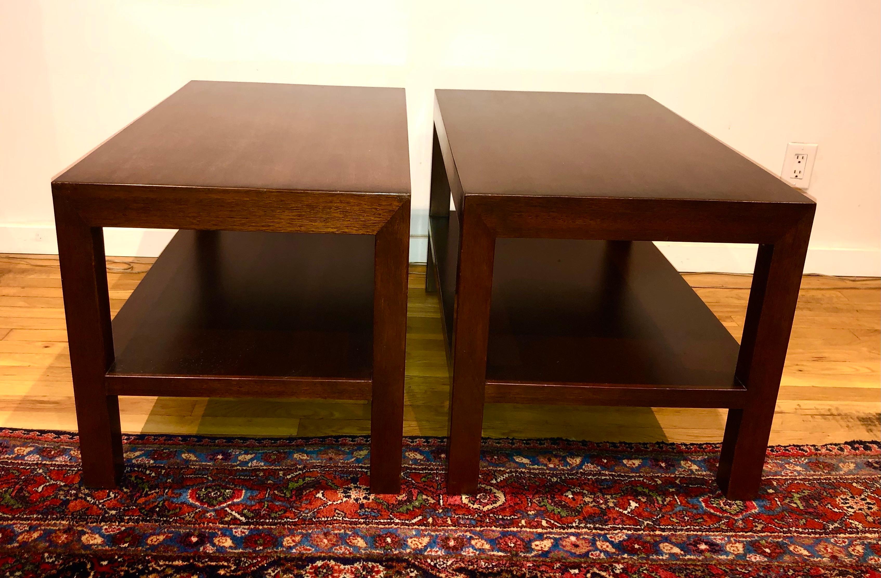 Simple, perfectly proportioned two-tiered walnut side tables, designed by Edward Wormley. Model 4533 from 1945. Both tables retain paper labels and Dunbar brand.