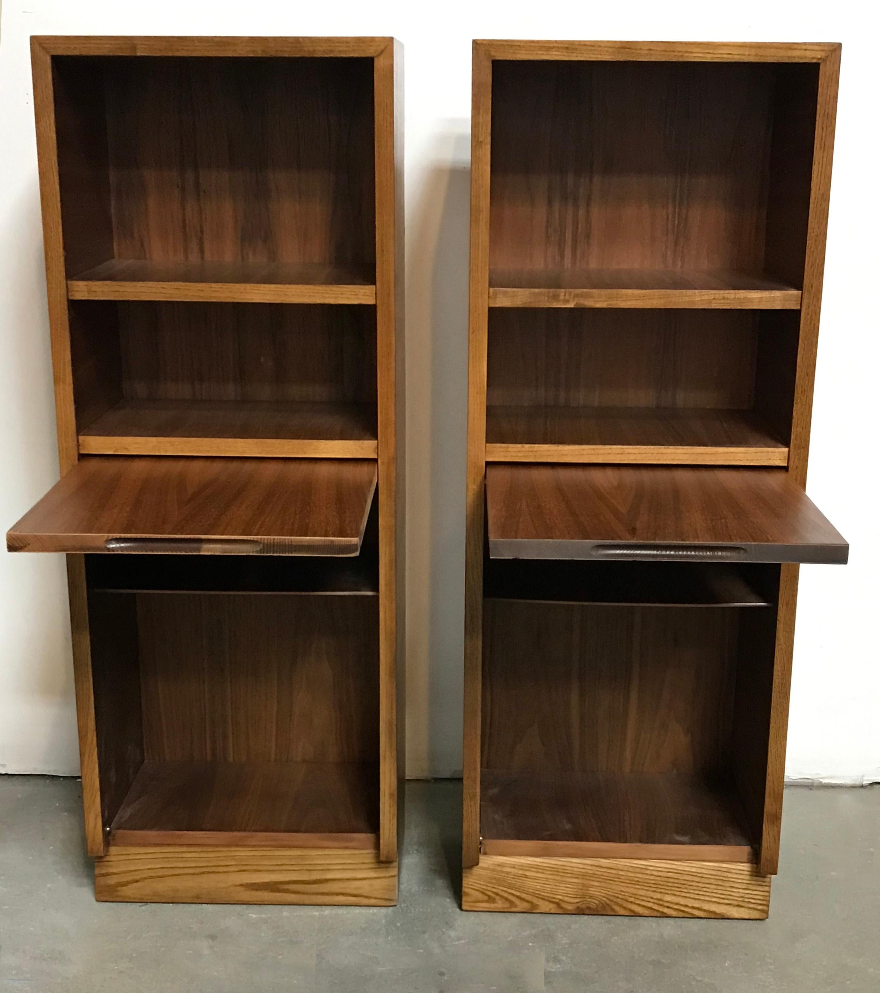 A pair of tables with a quirky configuration in the form of two, open shelves and two, bottom shelves hidden behind a pull-up board. Can be used as nightstands or pedestals too.
