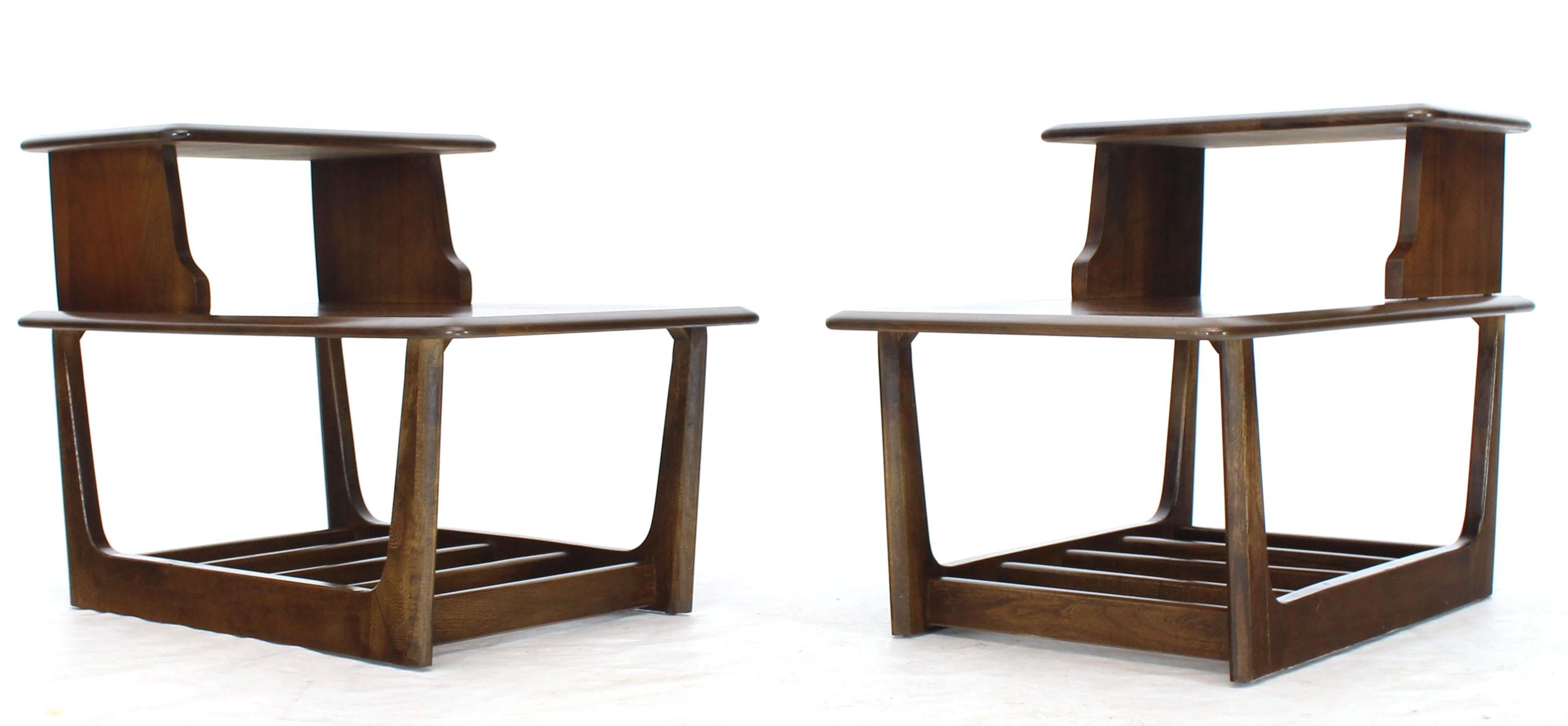 Mid-Century Modern pair of walnut rounded sides step end tables with optional magazine rack in the bottom. Sharp looking design beautiful original condition.