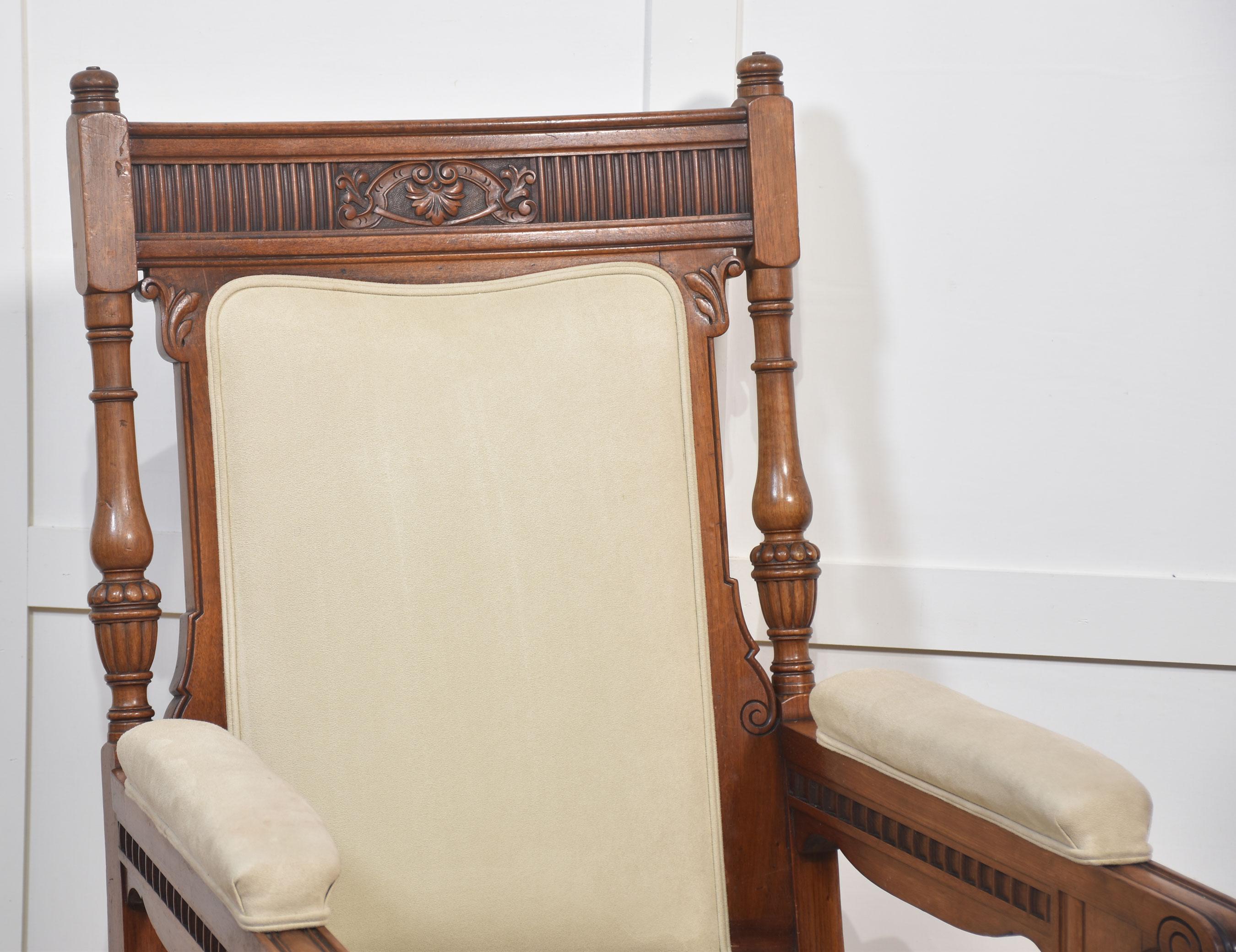 Paire de fauteuils de bibliothèque en noyer, dont la traverse supérieure est moulurée et sculptée, et dont le dossier et l'assise sont recouverts de daim. Flanqué d'accoudoirs à coussinets ouverts, le tout reposant sur des pieds balustres cannelés