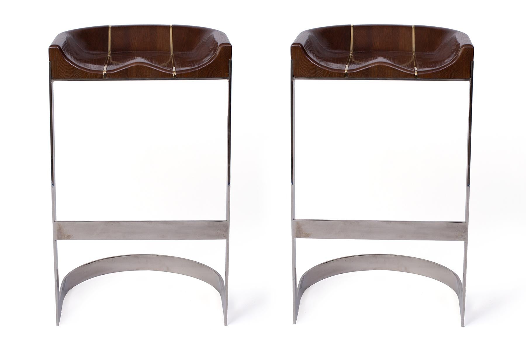 Early 1970s pair of solid oak and chrome barstools by Warren Bacon. Seats feature sleek brass inlay details. Price listed is for the pair.