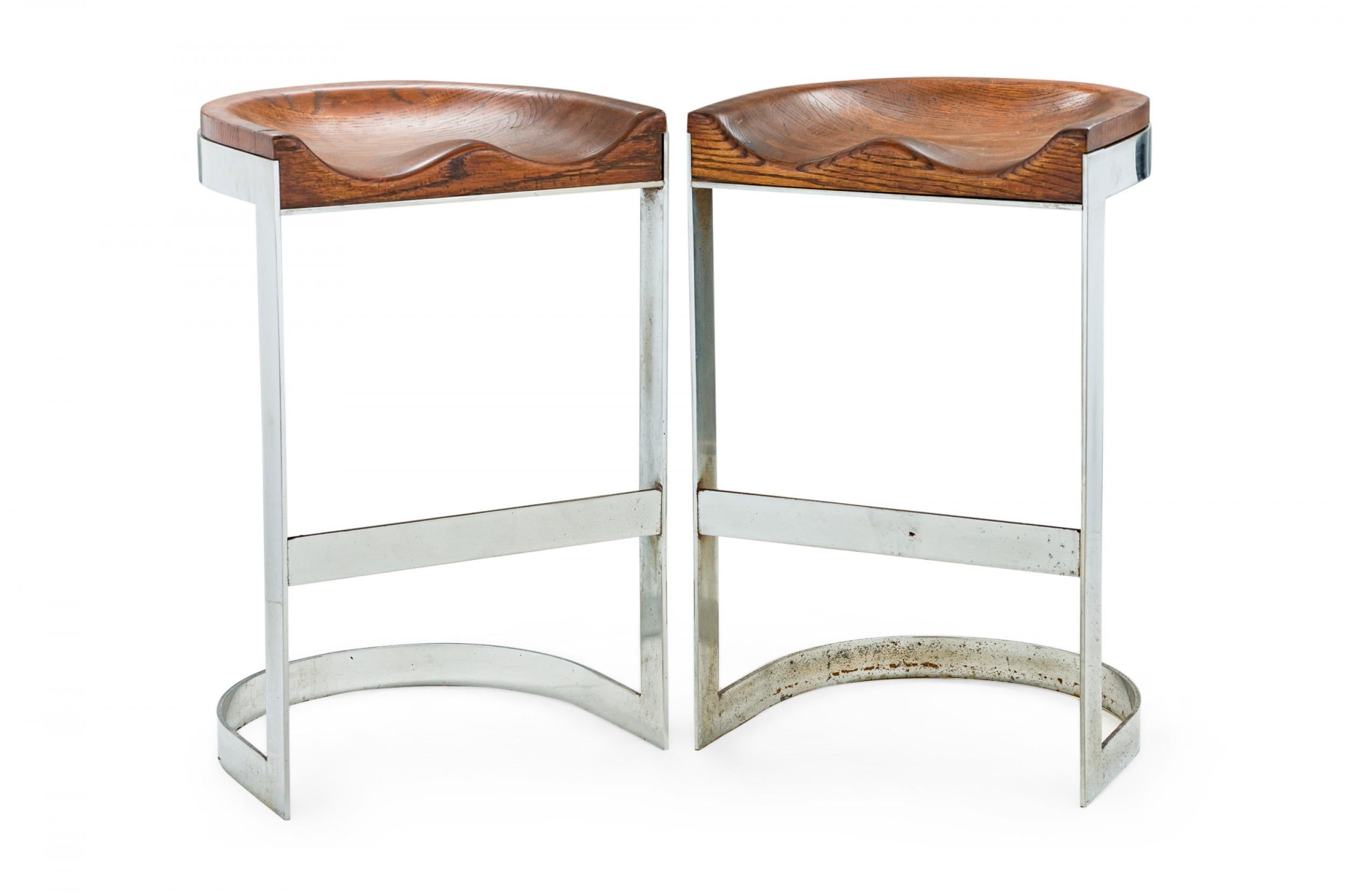Pair of Mid-Century American sculpted wood tractor style bar stools smoothly contoured for a comfortable fit on horseshoe cantilevered chrome frames. (WARREN BACON) (PRICED AS Pair)

Wear to finish.