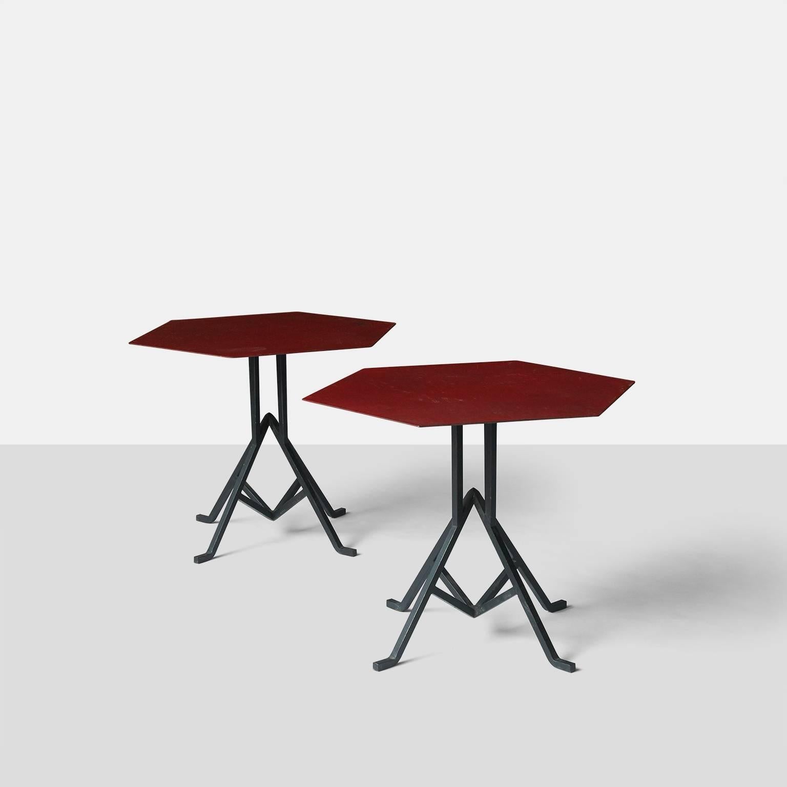 A pair of iron base coffee tables with a hexagon shaped metal top with the original red enamel finish. The metal base has an arrowhead motif which was used in Wright's early desert designs.
The tables were made in 1927 for the Biltmore Hotel in