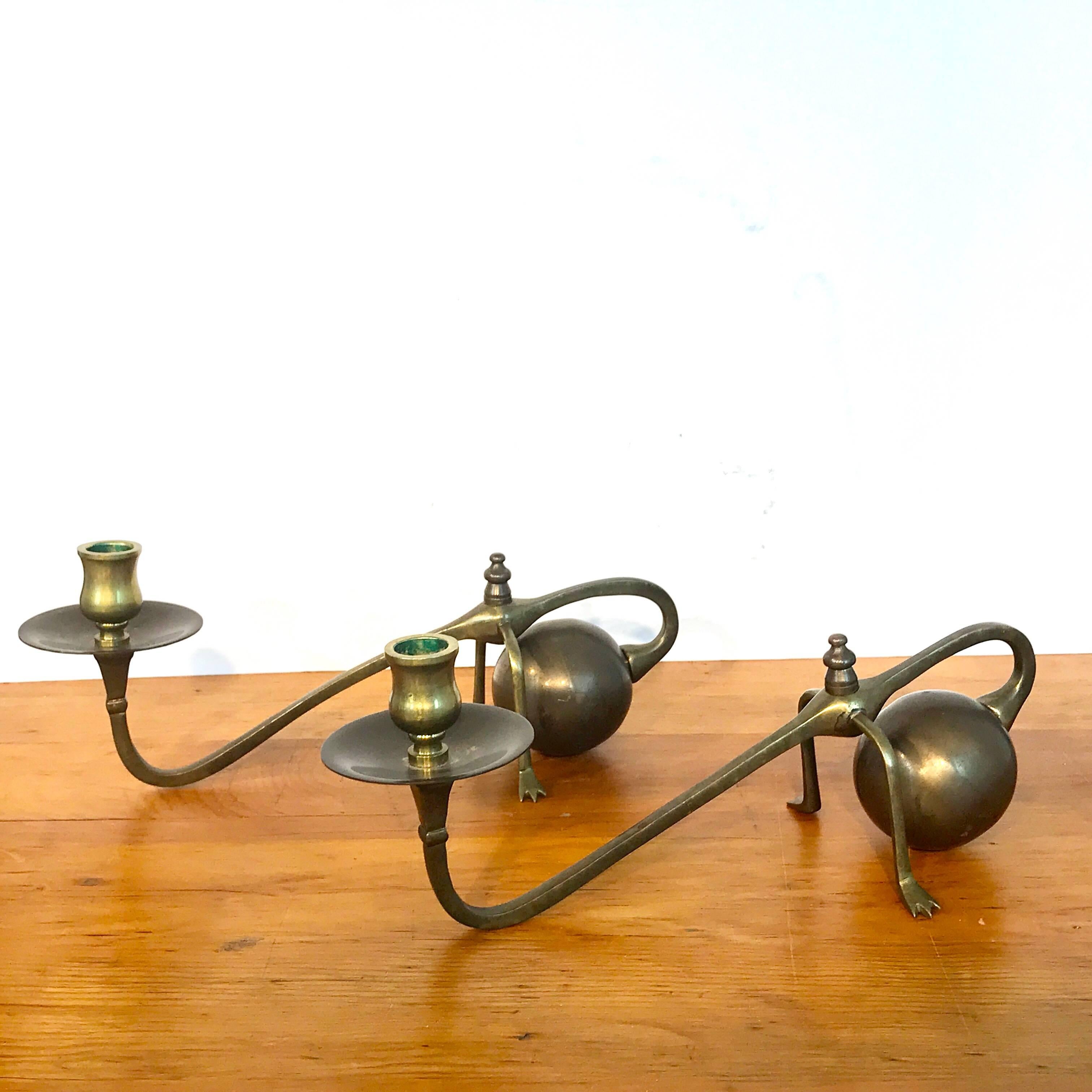 Pair of W.A.S Benson style brass candlesticks, each one of counterbalance form with paw feet.