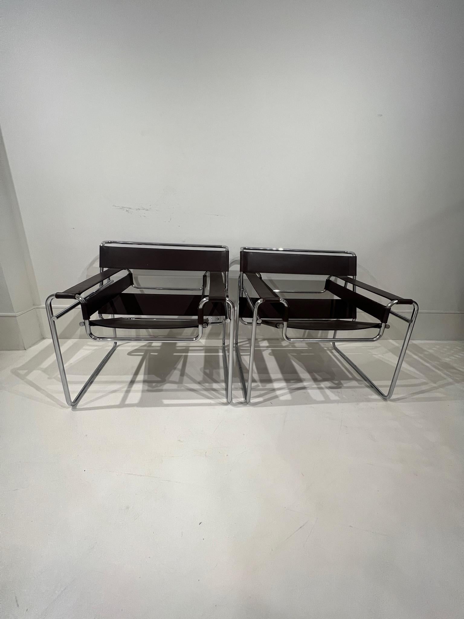 Immediately recognizable as a classic mid-century icon, this identical pair will transform any room into a casual/chic environment.  These chairs are in remarkable good condition with very minor losses on some of the leather.   
