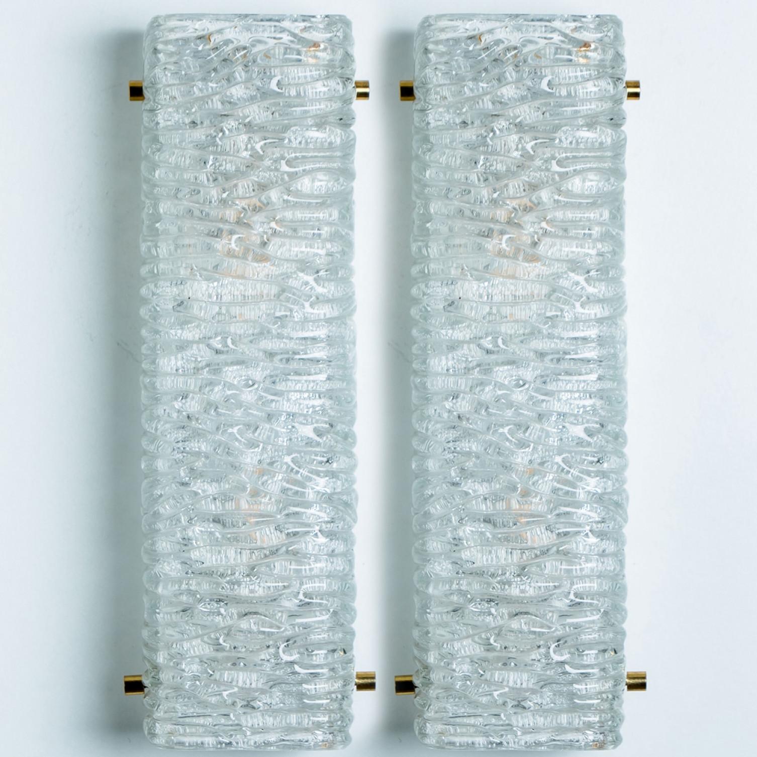 Pair of Beautiful high quality light fixture made by Kalmar, Austria. Manufactured in mid century, circa 1970 (at the end of 1960s and beginning of 1970s).

This wall light features lights made of handmade wave ice glass and white back plate. The