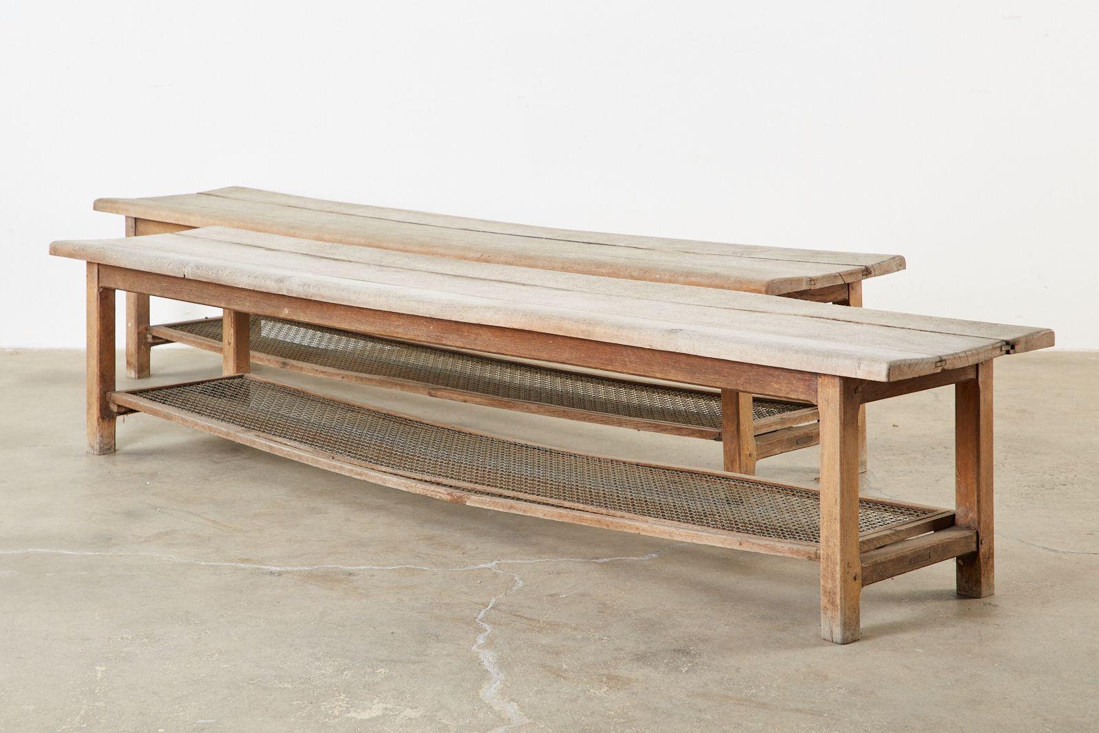Rustic pair of American pine benches featuring large storage shelves below the seat. The generous seats are crafted from thick 1 inch pine planks with tongue in groove joinery. The seat is supported by square chamfered legs conjoined by long