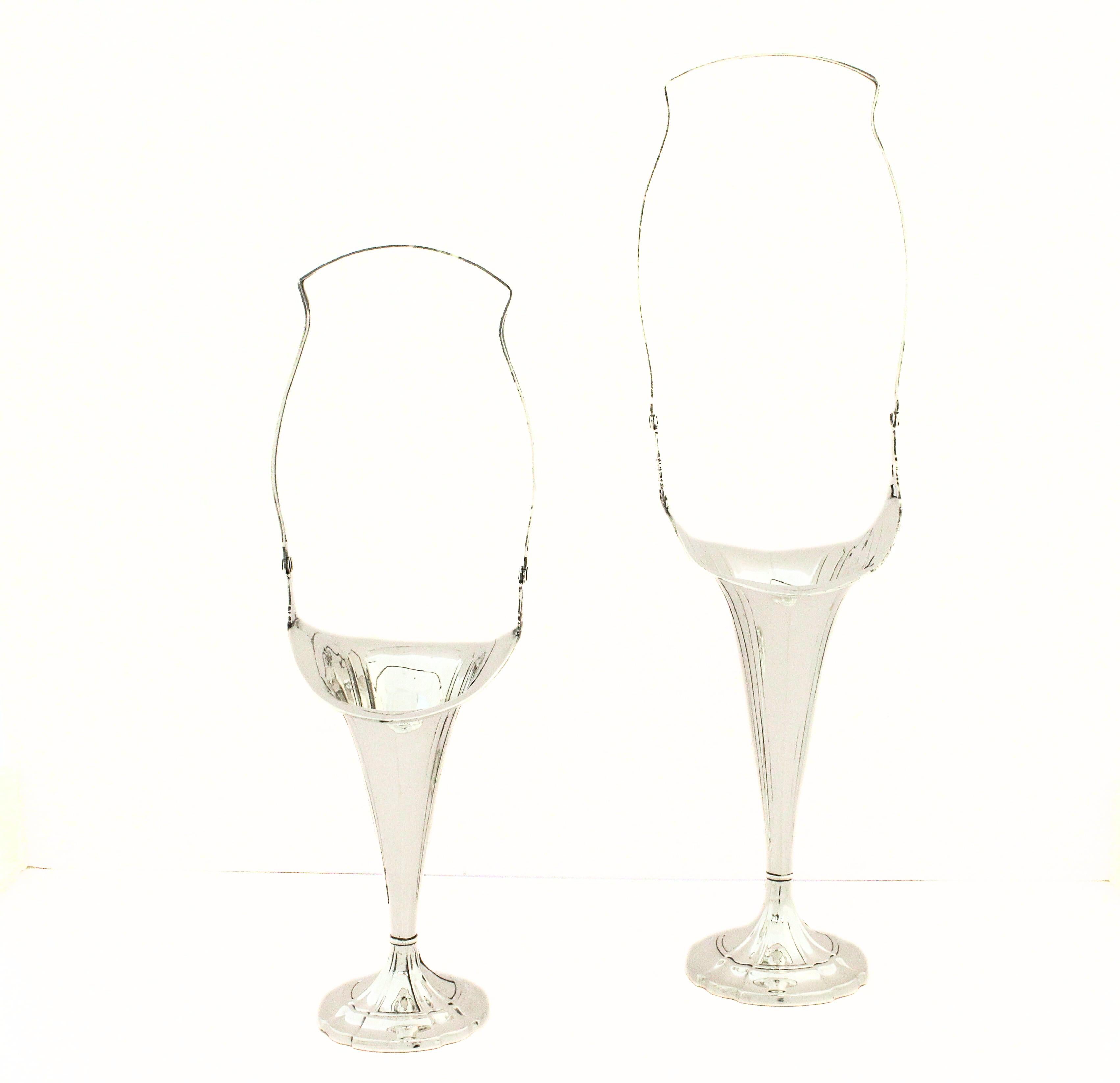 Questa elegante coppia di vasi/cestini in argento sterling è stata realizzata dalla Webster Company, un noto produttore americano di argento attivo dalla fine del XIX alla metà del XX secolo. Questi pezzi, caratterizzati da silhouette alte e