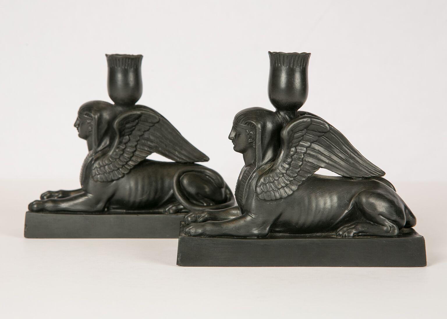 WHY WE LOVE IT: The beauty and strength of woman
A Sphinx has the head of a woman, the body of a lion, and a pair of wings. This pair of Wedgwood black basalt sphinxes, are modeled on a rectangular base with a 'lotus' shaped candleholder. The