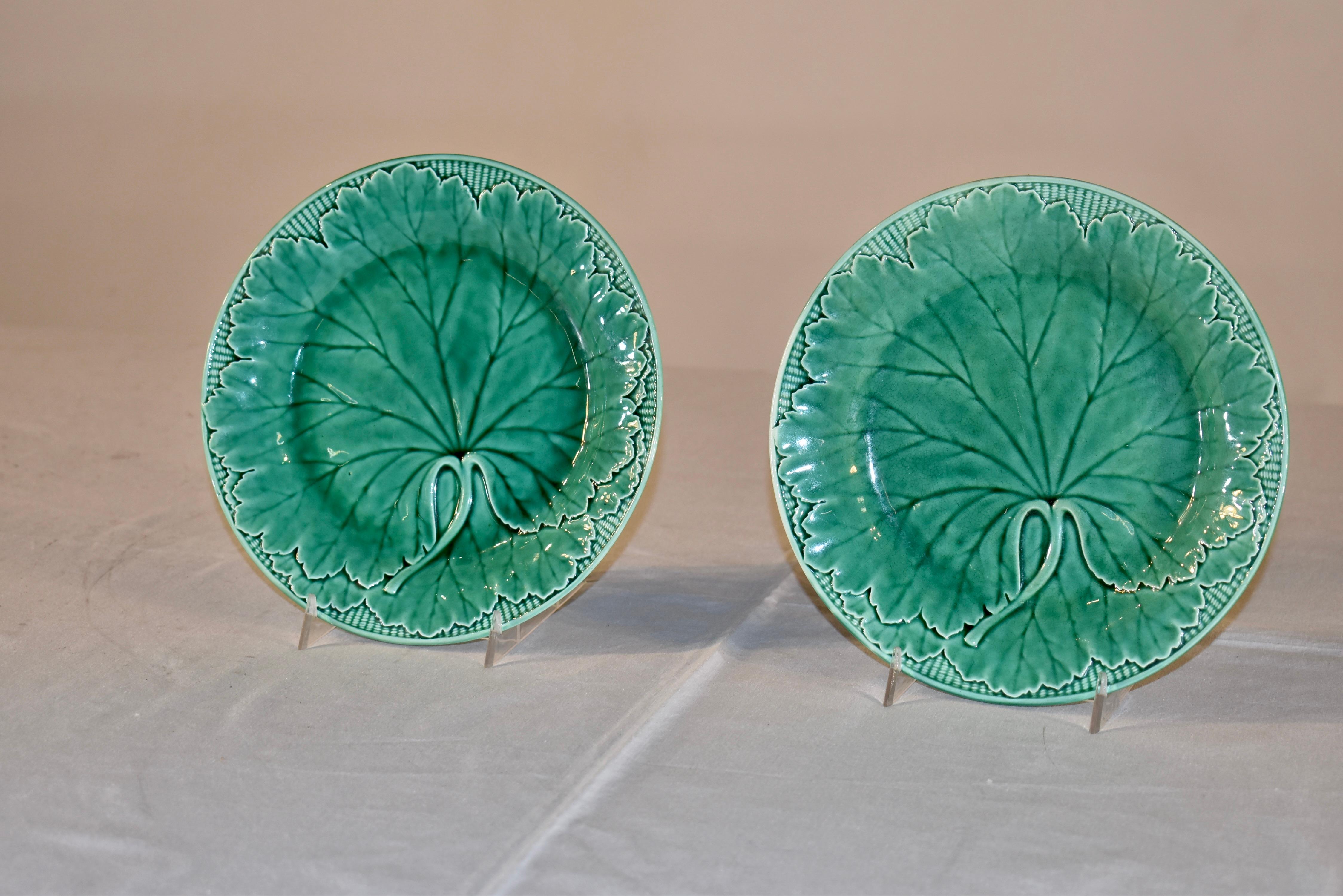 Ein Paar signierte Wedgwood Majolikateller, glasiert in einem schönen Grünton.  Die Teller haben ein Korb- und Blattmuster, das zu den am meisten gesammelten Mustern von Wedgwood gehört.  Auf den Rückseiten steht außerdem 