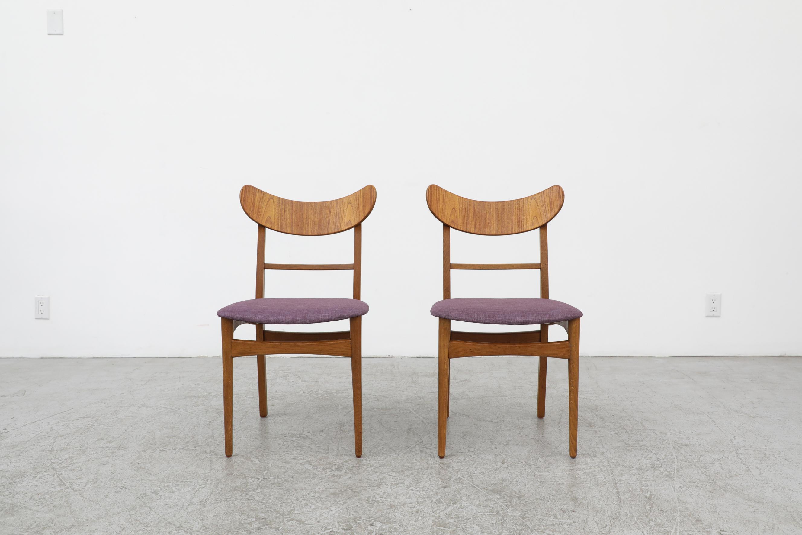 Pair of Wegner style dining chairs with curved teak almond shaped backrests and newer upholstered seats in purple. In original condition with some wear to the frame including a small crack on the left side of one of the side rails of one chair. The