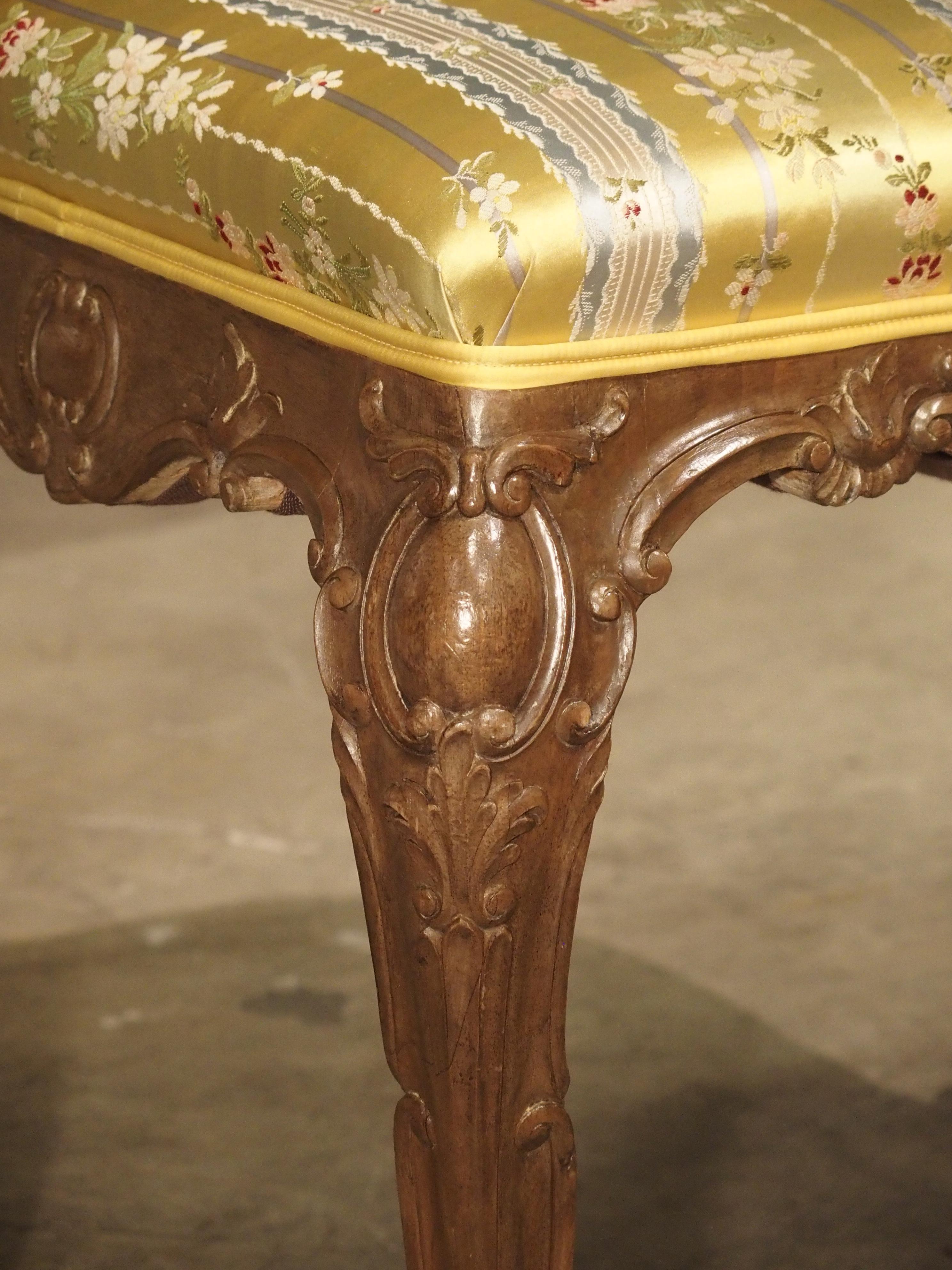 This pair of well carved Louis XV style tabourets are covered in an elegant floral silk upholstery and stand at just over 21 inches tall. The term tabouret comes from the old French, tabour, (“small drum”), as the original 17th century tabourets