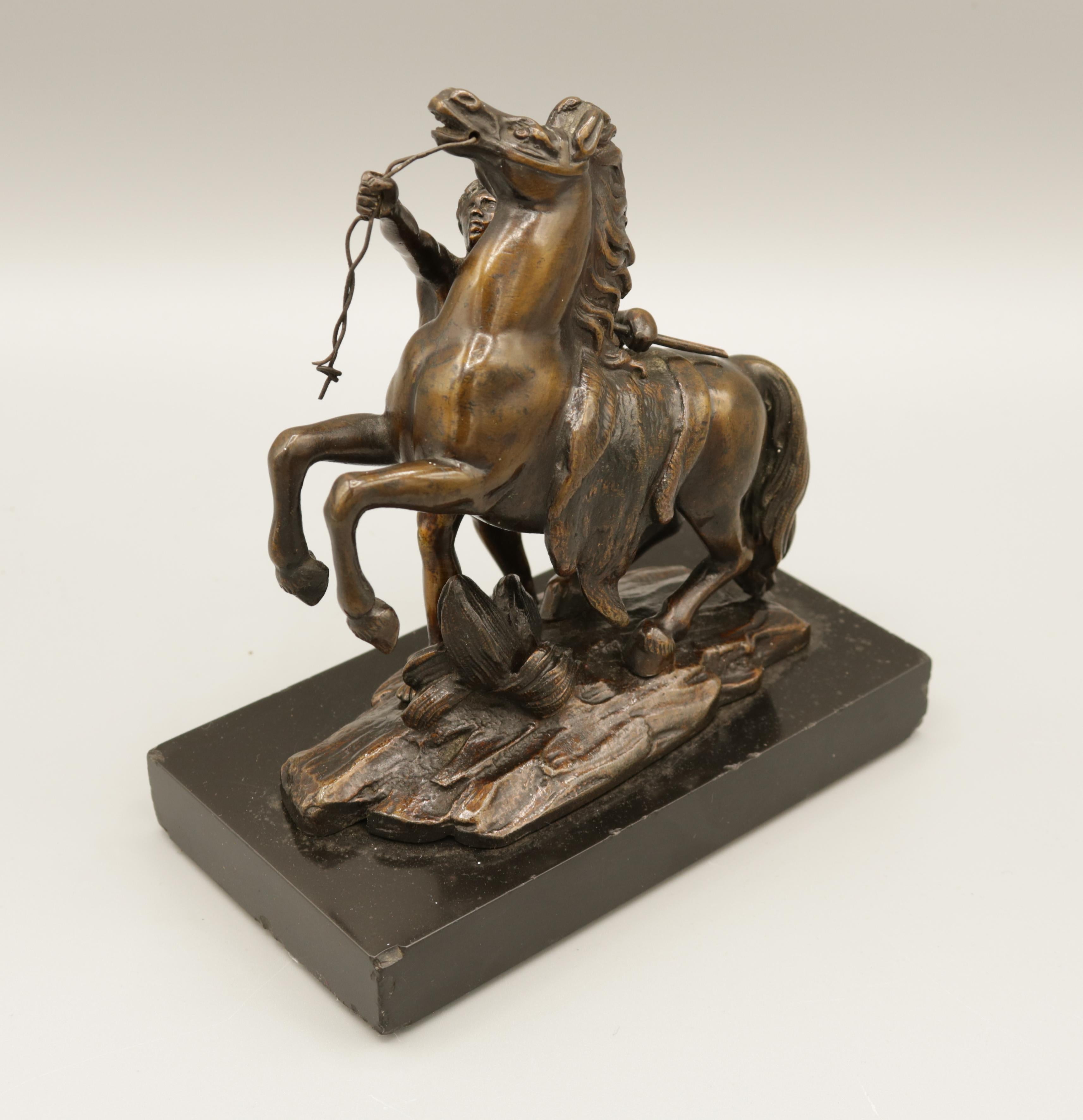 A small pair of fine quality well cast bronze models of the 'Chevaux de Marly', each with a man and rearing horse raised on rectangular plinth bases. The Carrara marble originals commissioned from the workshop of brothers Nicolas & Guillaume Coustou